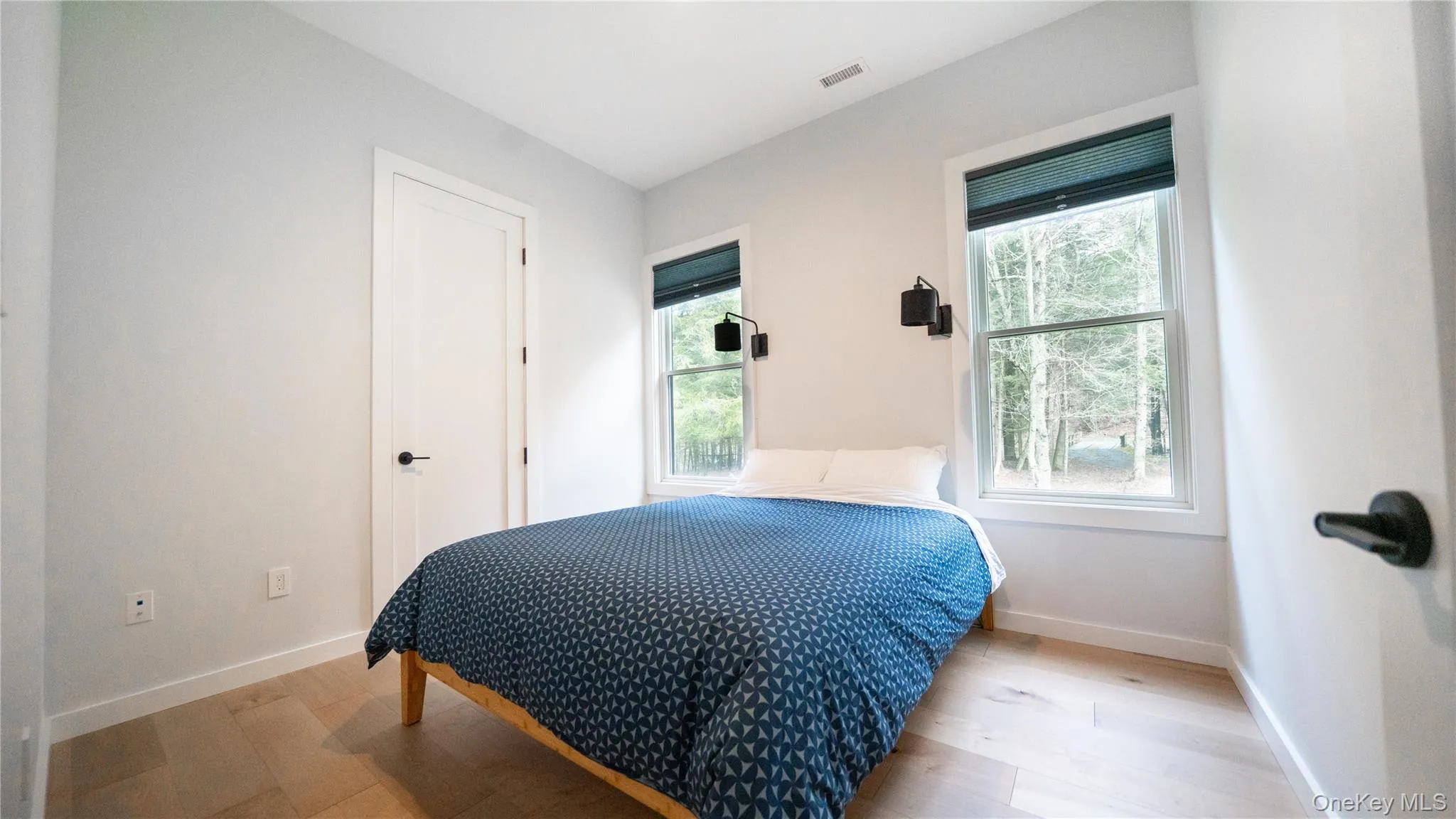 Bedroom with light wood-type flooring and baseboards Bedroom with light wood-type flooring and baseboards