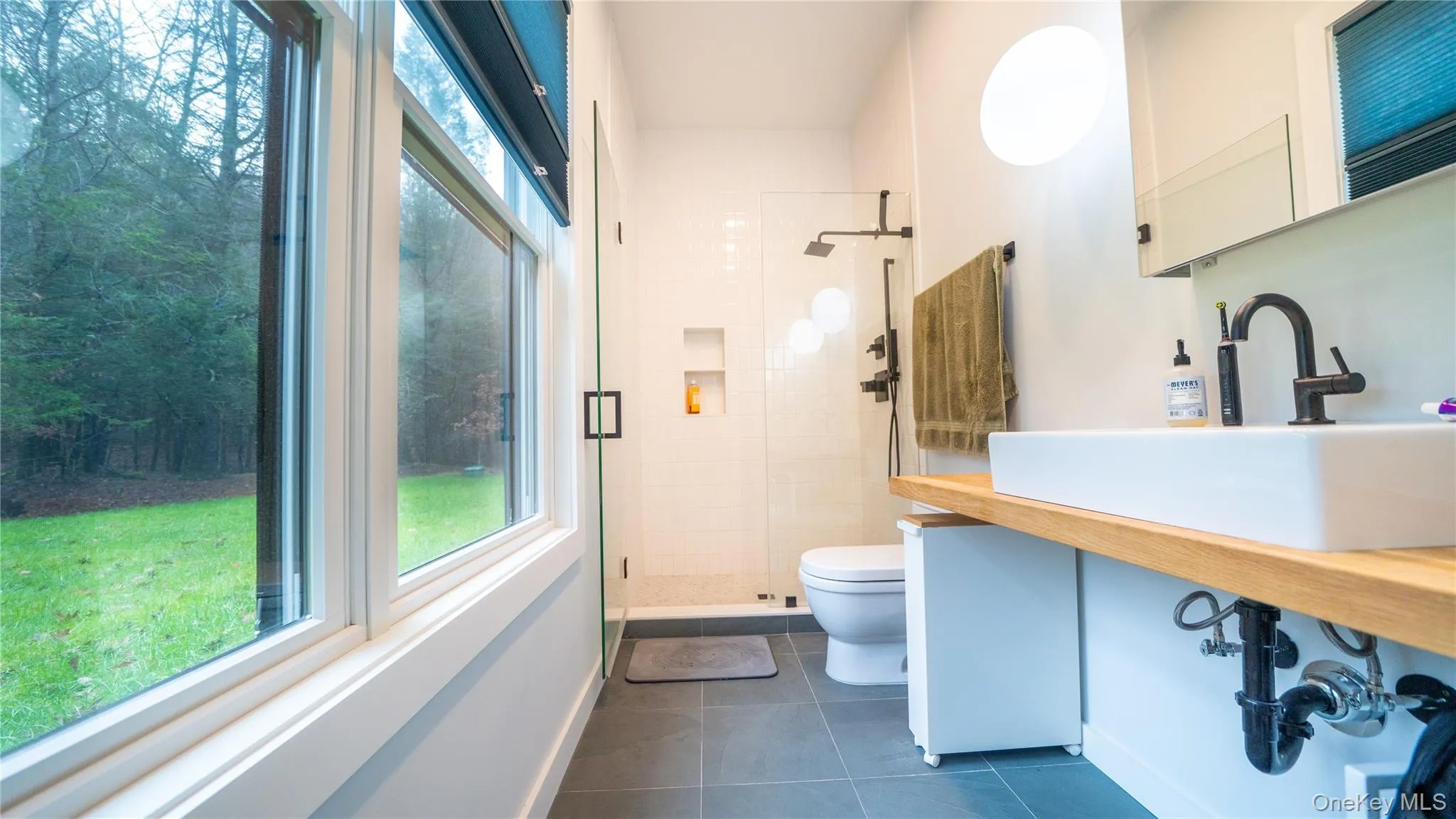 Full bath with a stall shower, dark tile patterned floors, and vanity Full bath with a stall shower, dark tile patterned floors, and vanity