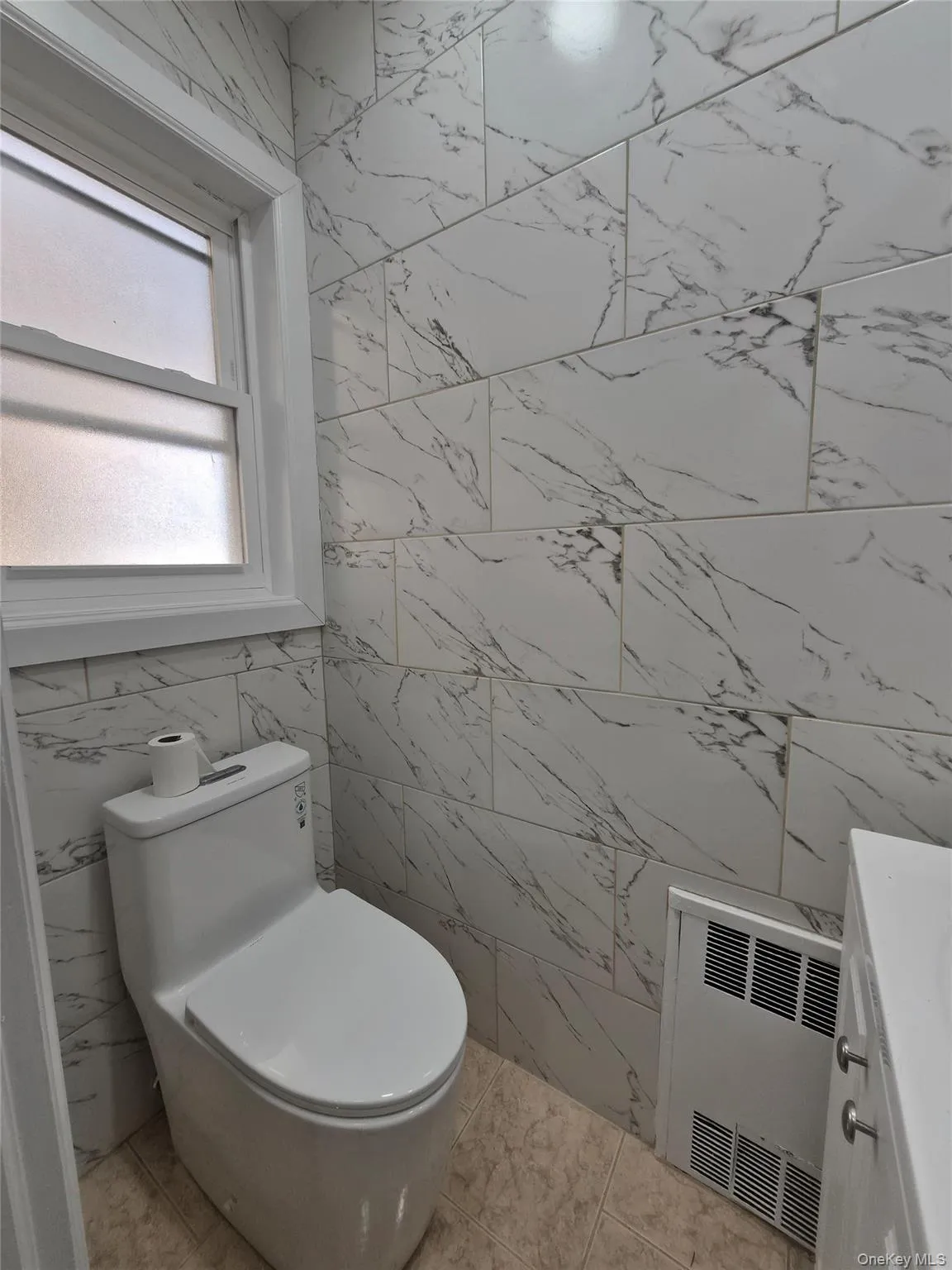 Bathroom with tile walls, vanity, radiator heating unit, and heating unit Bathroom with tile walls, vanity, radiator heating unit, and heating unit