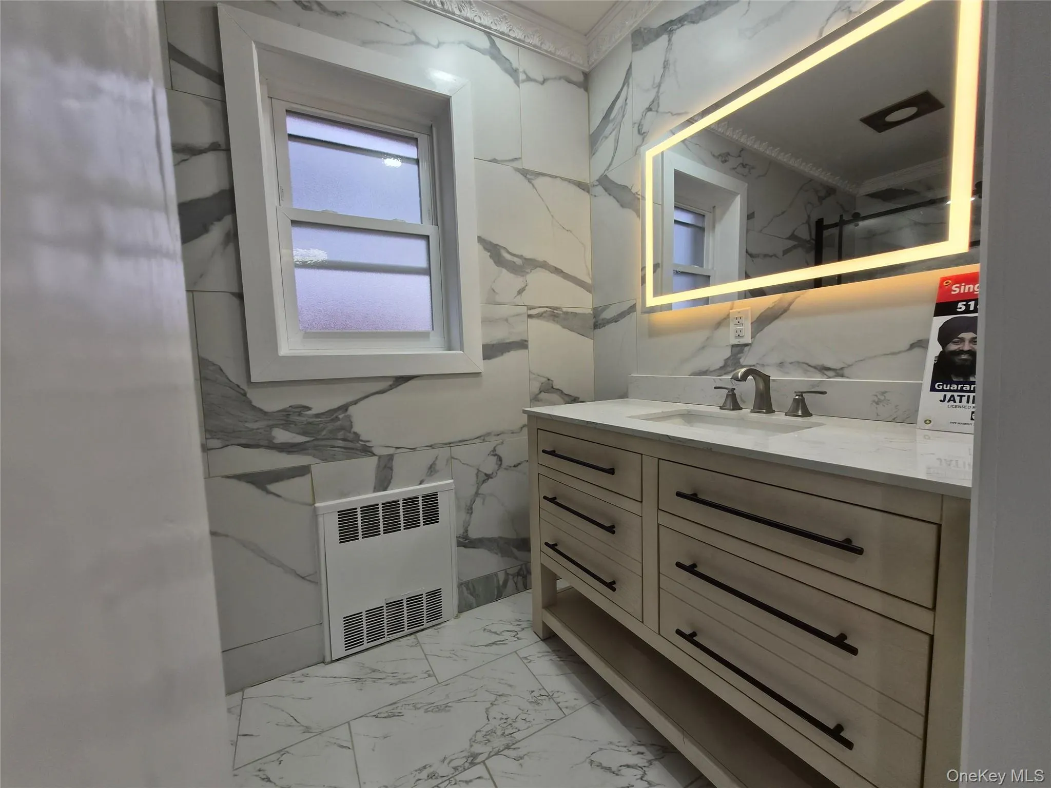 Bathroom with vanity, radiator heating unit, crown molding, and light marble finish flooring Bathroom with vanity, radiator heating unit, crown molding, and light marble finish flooring