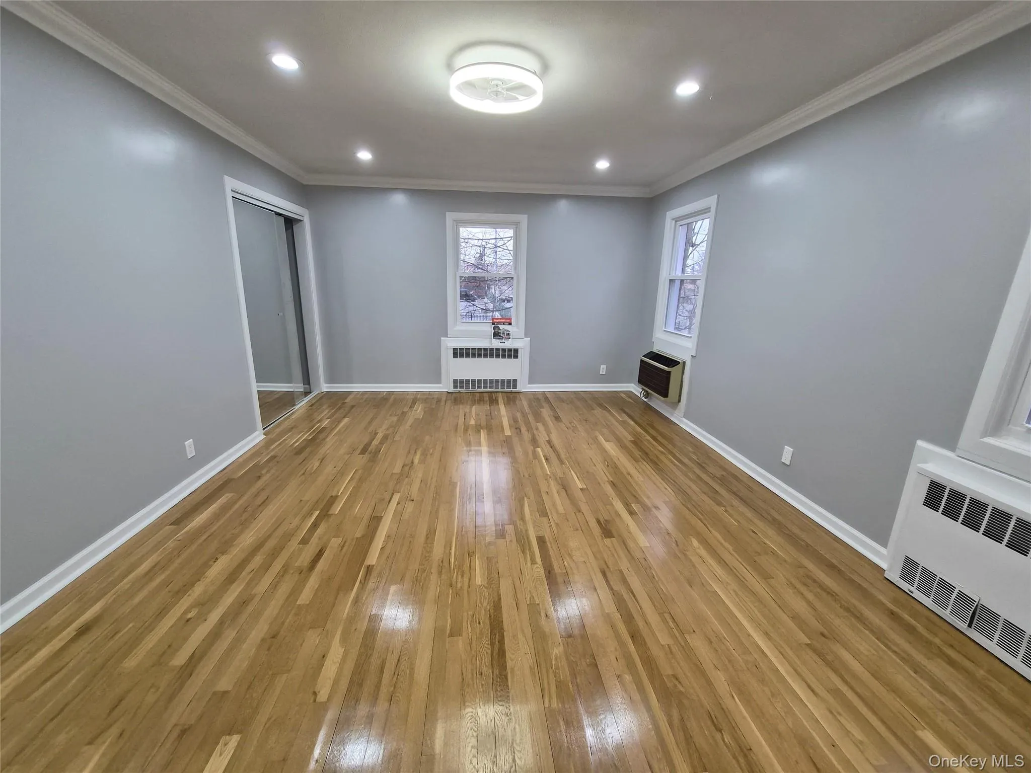 Spare room featuring recessed lighting, light wood finished floors, radiator, and crown molding Spare room featuring recessed lighting, light wood finished floors, radiator, and crown molding