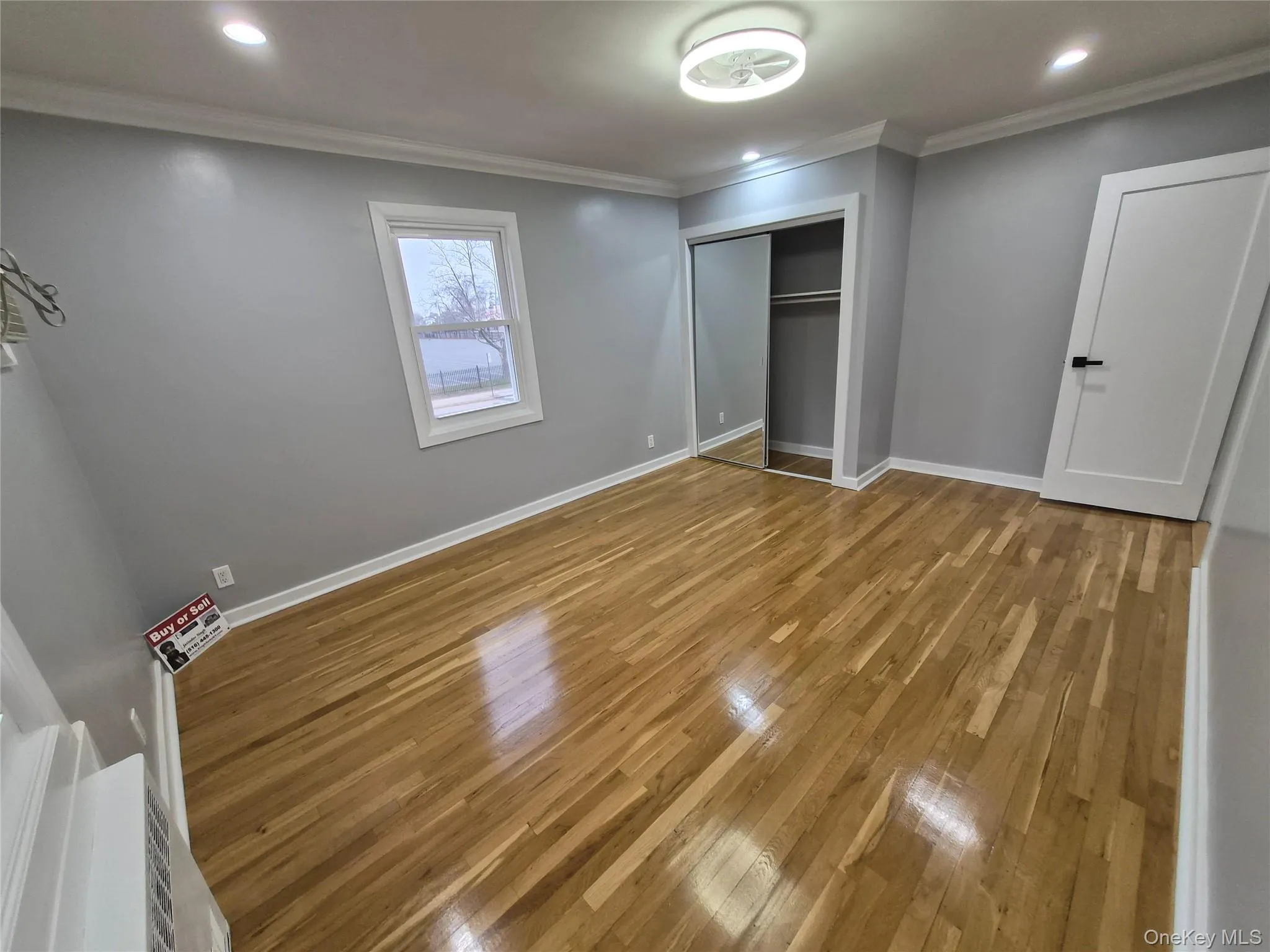 Unfurnished bedroom with wood finished floors, ornamental molding, recessed lighting, and a closet Unfurnished bedroom with wood finished floors, ornamental molding, recessed lighting, and a closet