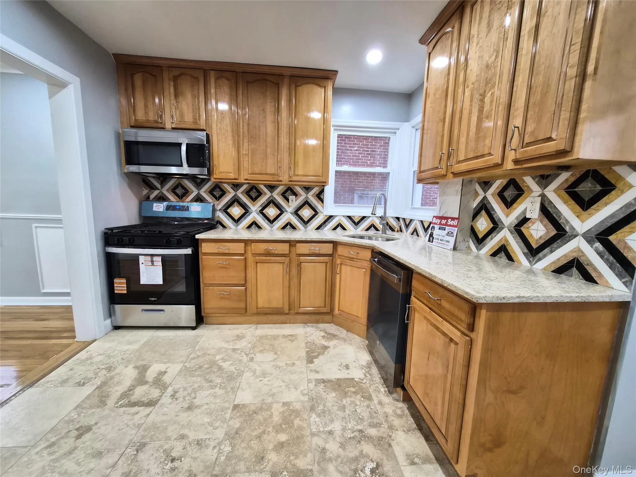 Kitchen featuring appliances with stainless steel finishes, brown cabinetry, light stone counters, and backsplash Kitchen featuring appliances with stainless steel finishes, brown cabinetry, light stone counters, and backsplash