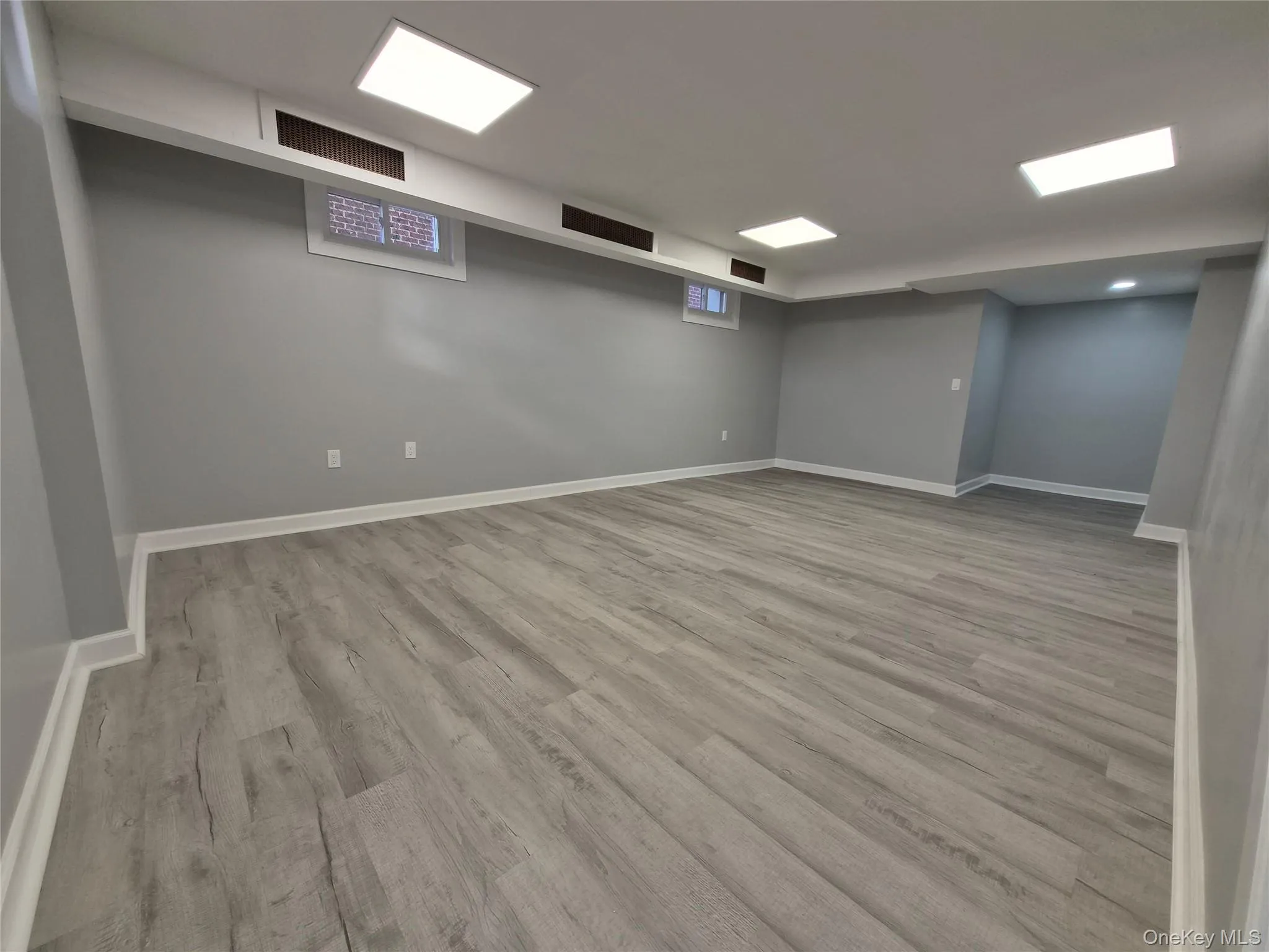 Finished below grade area with light wood-style flooring and baseboards Finished below grade area with light wood-style flooring and baseboards
