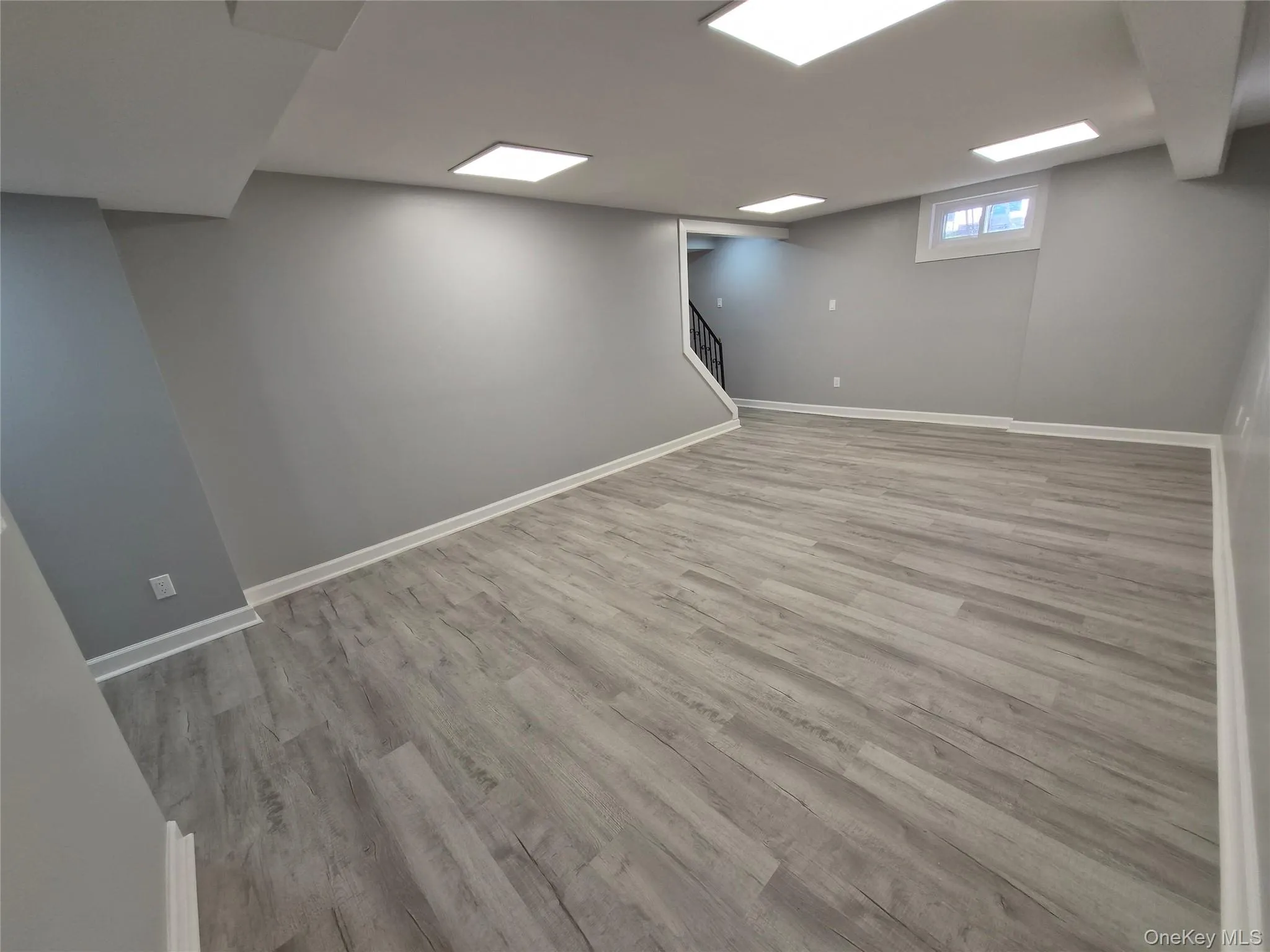 Basement featuring stairway and light wood-style floors Basement featuring stairway and light wood-style floors