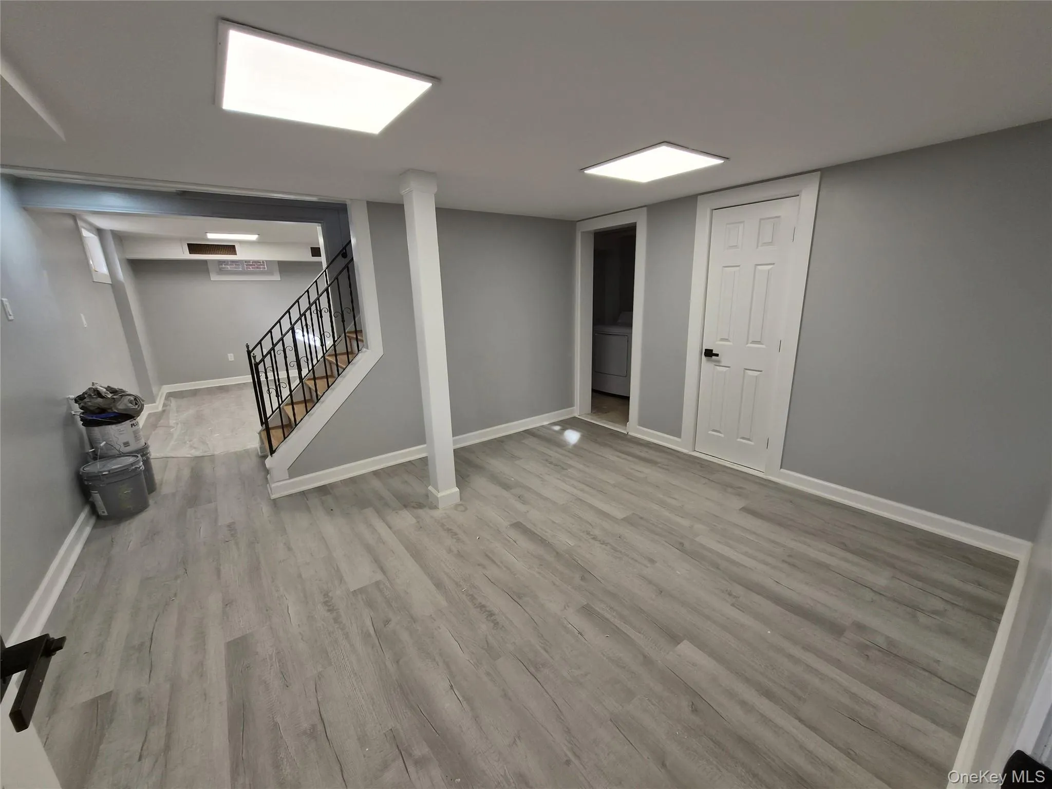 Finished basement featuring stairs, light wood-type flooring, and washer / dryer Finished basement featuring stairs, light wood-type flooring, and washer / dryer