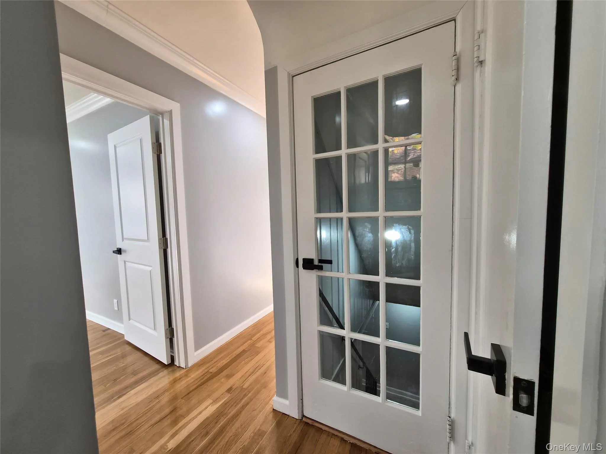 Hall with crown molding and wood finished floors Hall with crown molding and wood finished floors