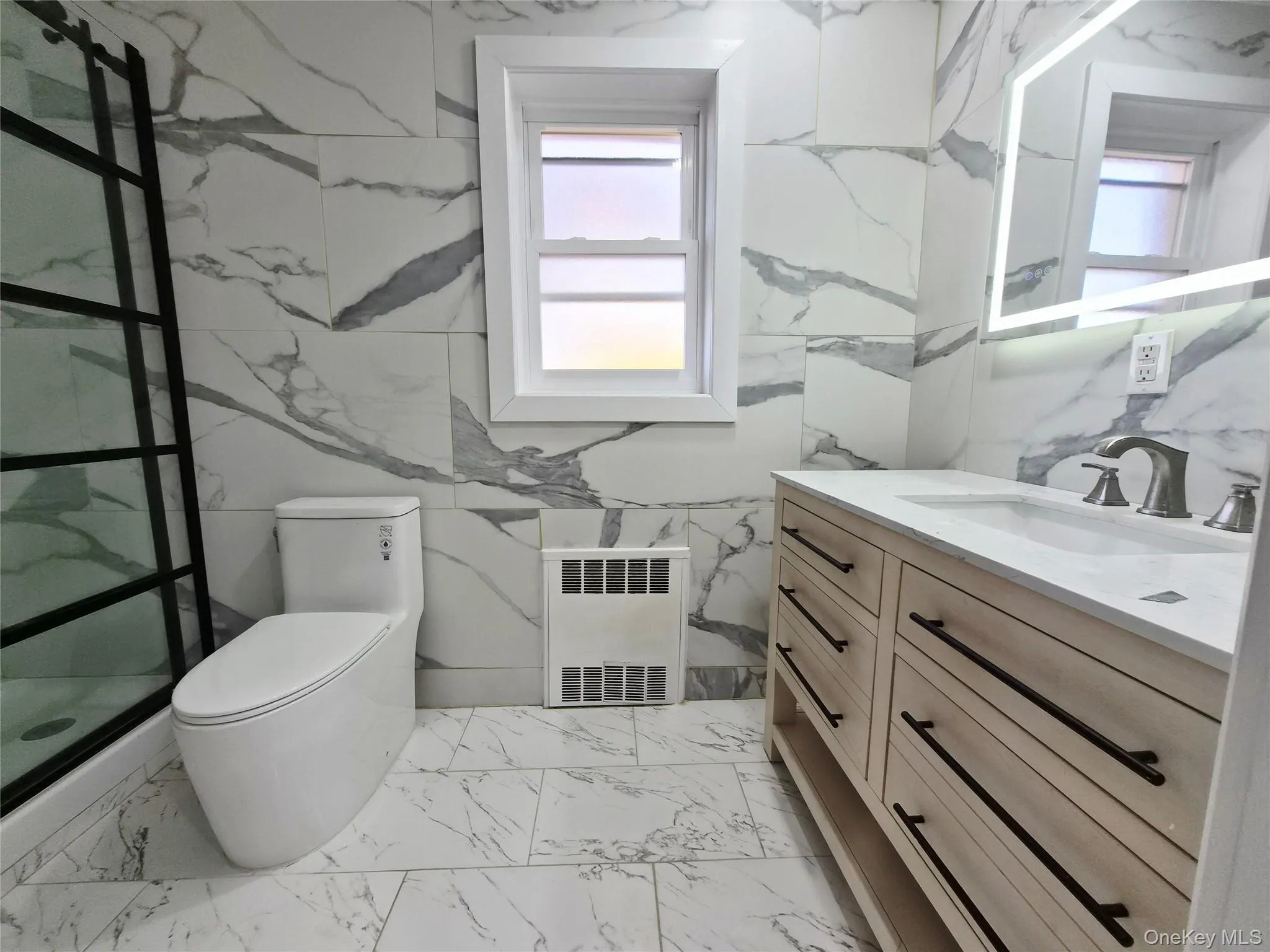 Bathroom with vanity, radiator heating unit, and light marble finish flooring Bathroom with vanity, radiator heating unit, and light marble finish flooring