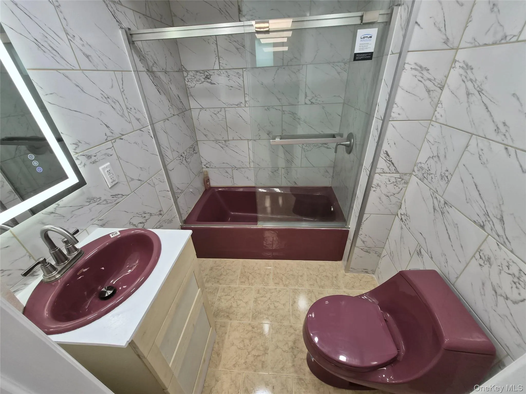 Full bath with tile walls, shower / bath combination with glass door, and vanity Full bath with tile walls, shower / bath combination with glass door, and vanity