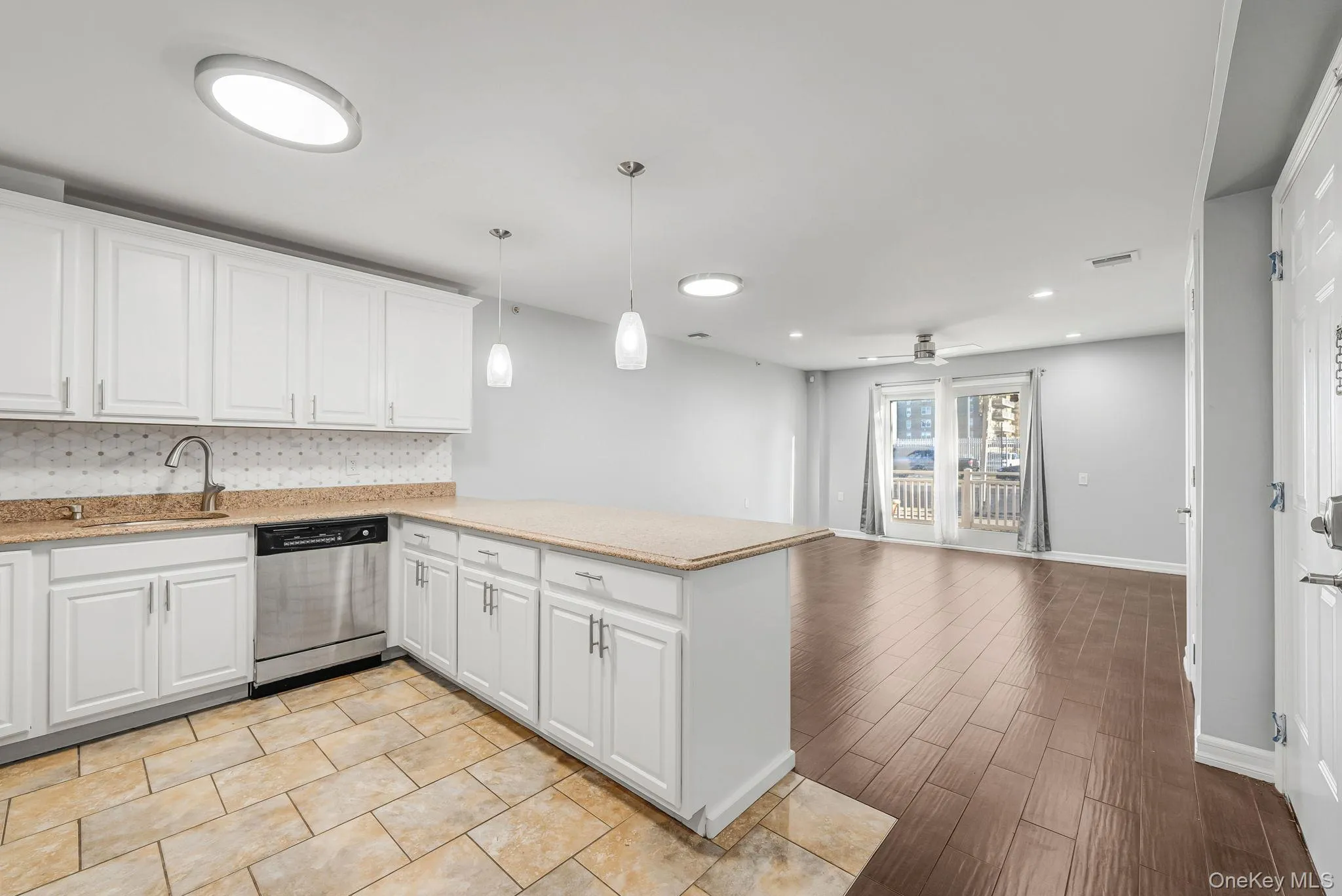 Kitchen featuring pendant lighting, open floor plan, tasteful backsplash, white cabinets, and recessed lighting Kitchen featuring pendant lighting, open floor plan, tasteful backsplash, white cabinets, and recessed lighting