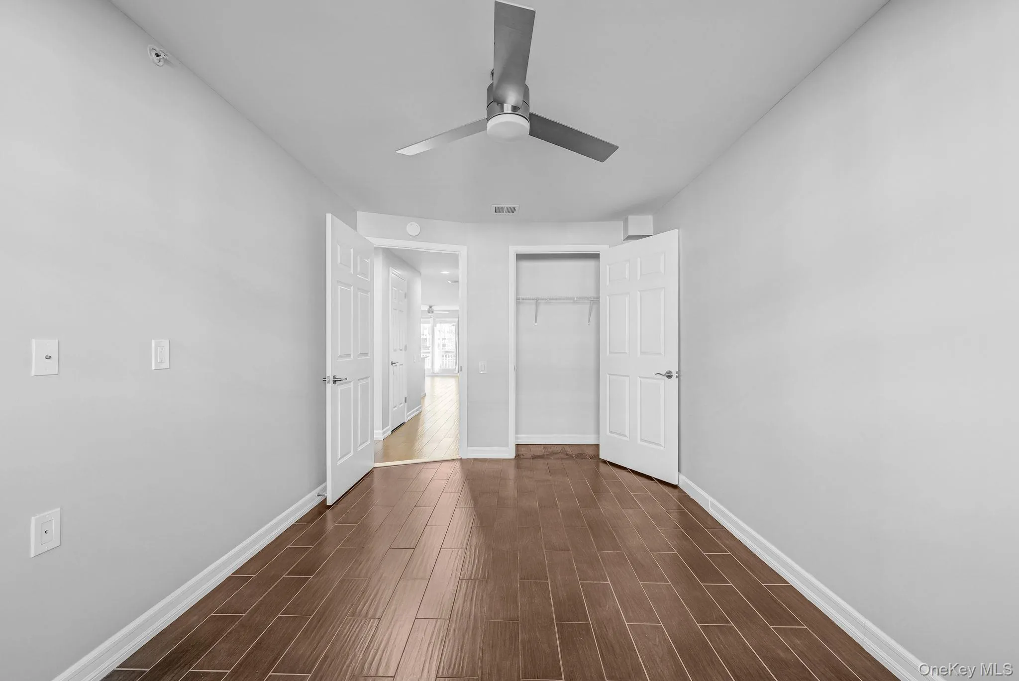 Unfurnished bedroom featuring a closet, wood tiled floors, and a ceiling fan Unfurnished bedroom featuring a closet, wood tiled floors, and a ceiling fan