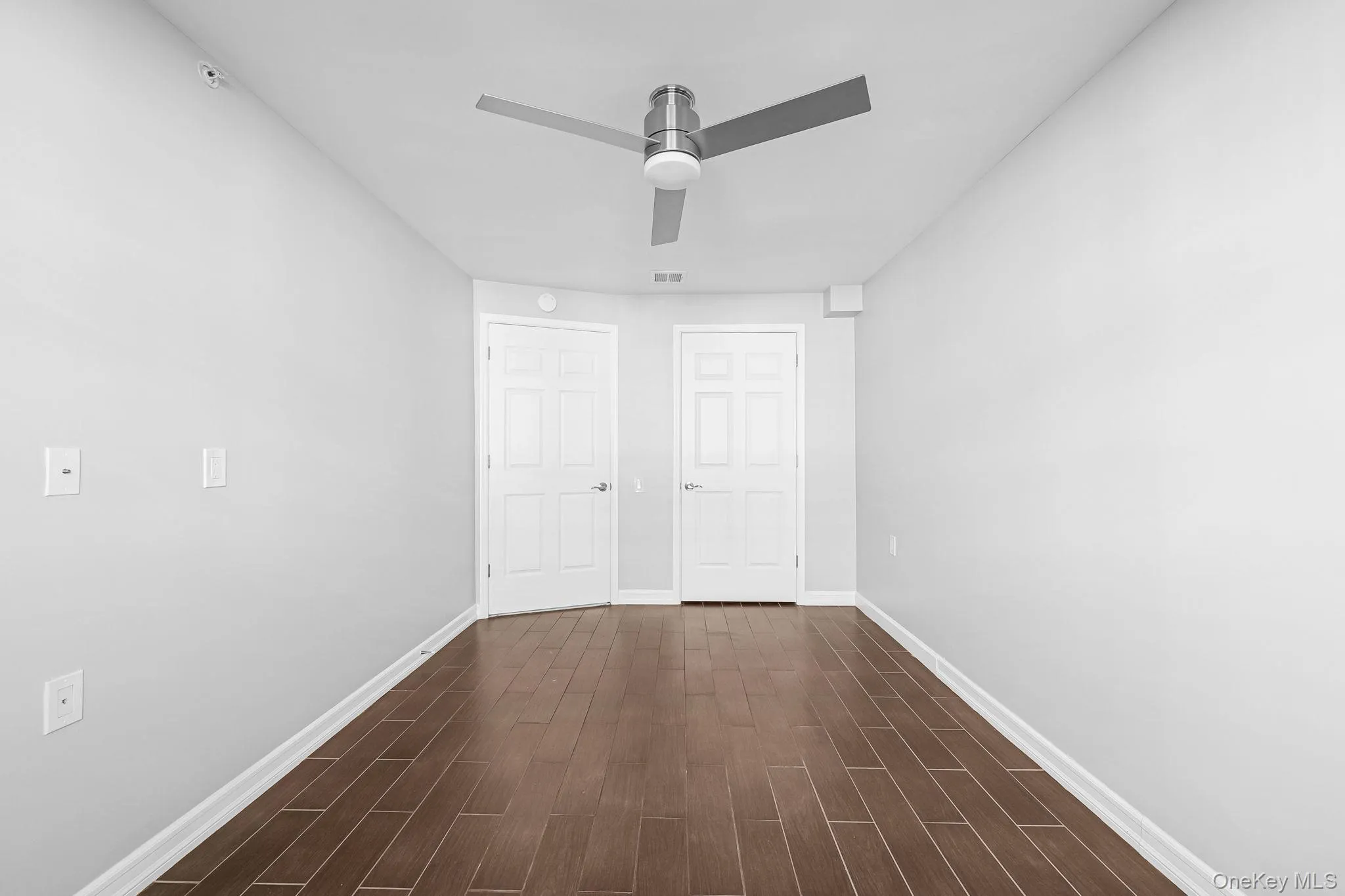 Unfurnished bedroom with dark wood-style flooring, a closet, and ceiling fan Unfurnished bedroom with dark wood-style flooring, a closet, and ceiling fan