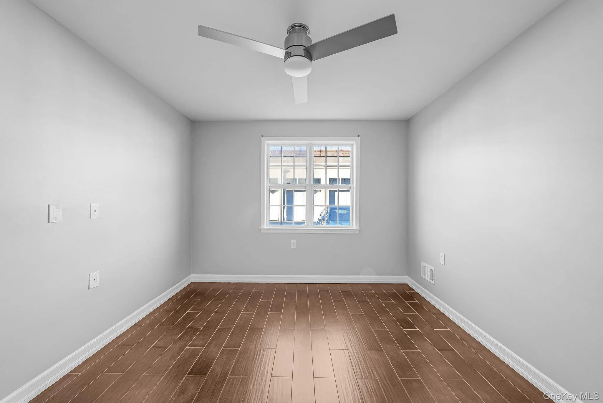 Unfurnished room with wood finish floors and a ceiling fan Unfurnished room with wood finish floors and a ceiling fan