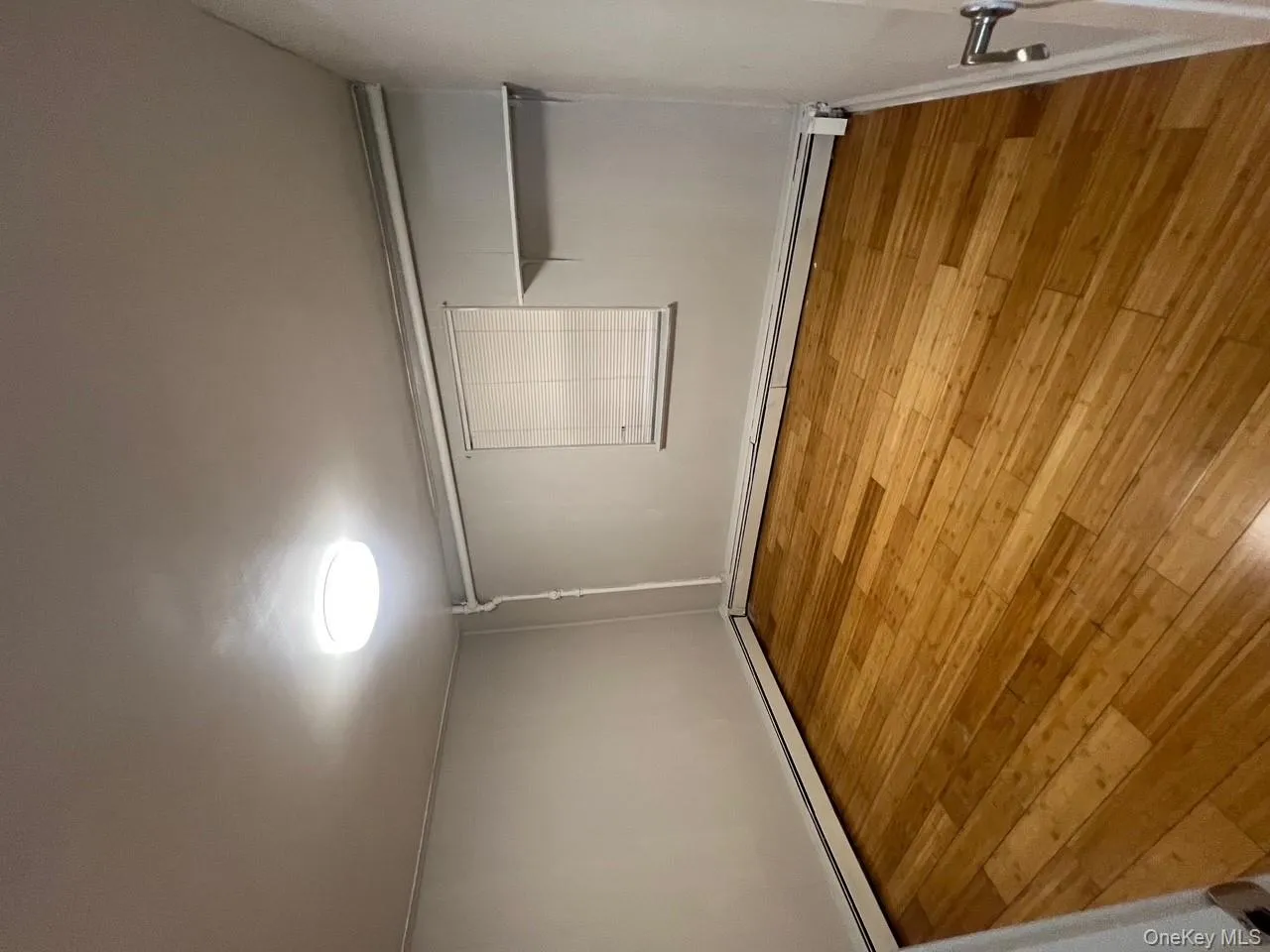 Unfurnished bedroom featuring light wood finished floors and a baseboard heating unit Unfurnished bedroom featuring light wood finished floors and a baseboard heating unit