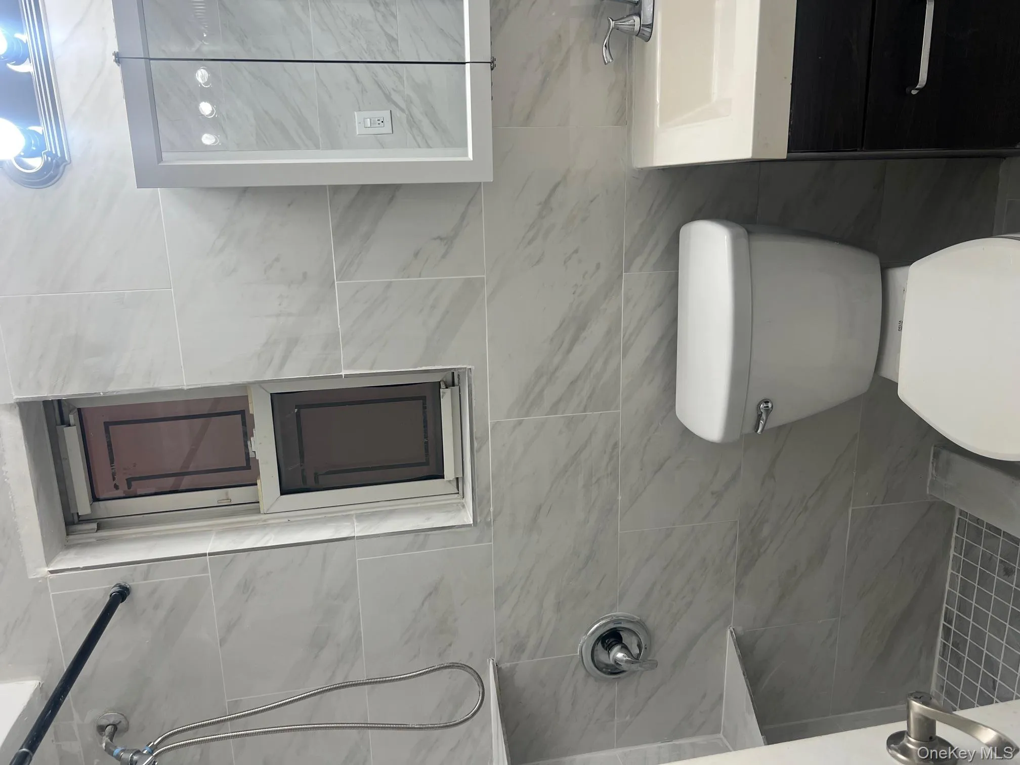 Full bathroom with tiled shower, vanity, and tile walls Full bathroom with tiled shower, vanity, and tile walls