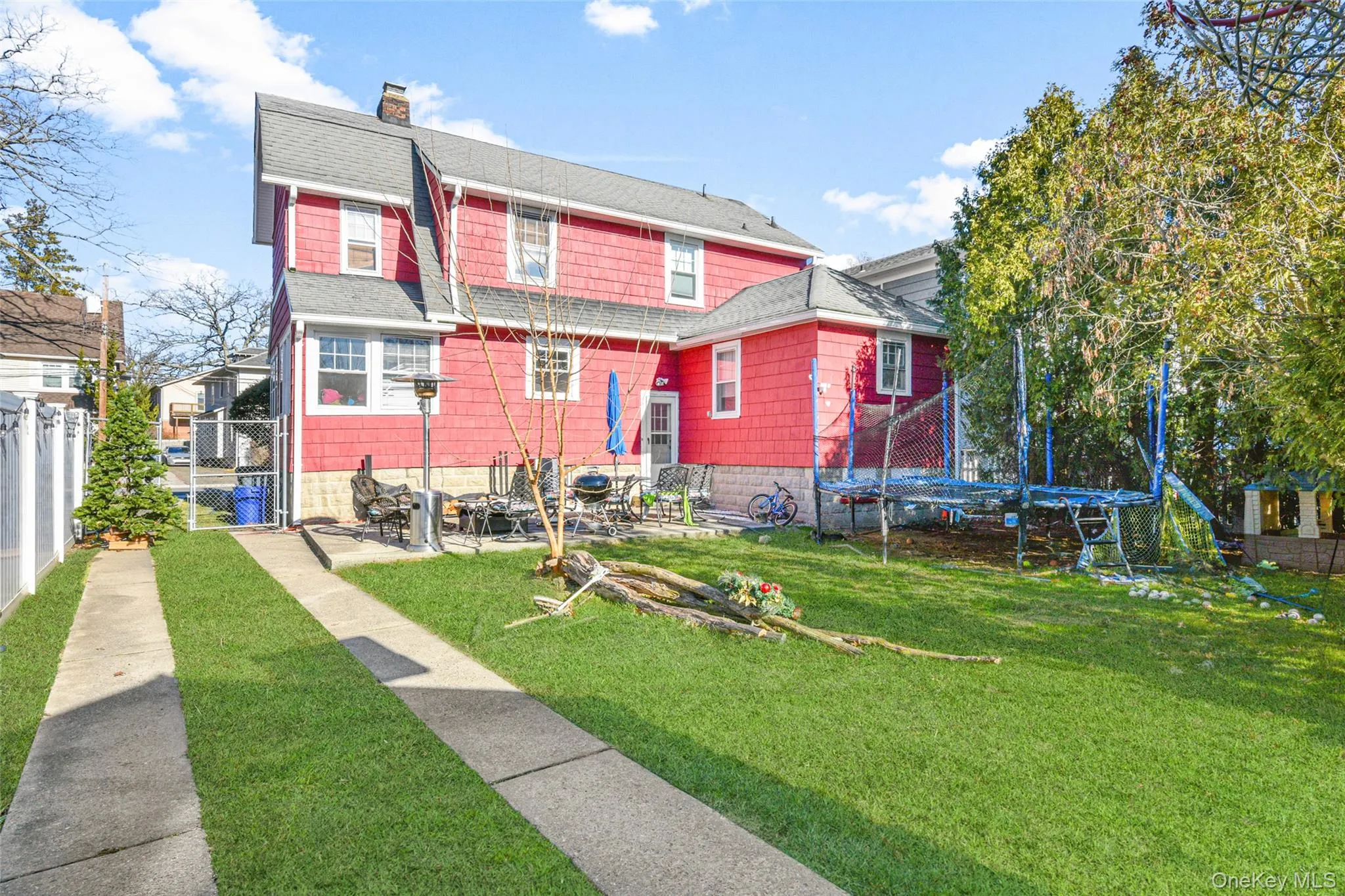 Back of property featuring a chimney, a fenced backyard, a shingled roof, and a gate Back of property featuring a chimney, a fenced backyard, a shingled roof, and a gate