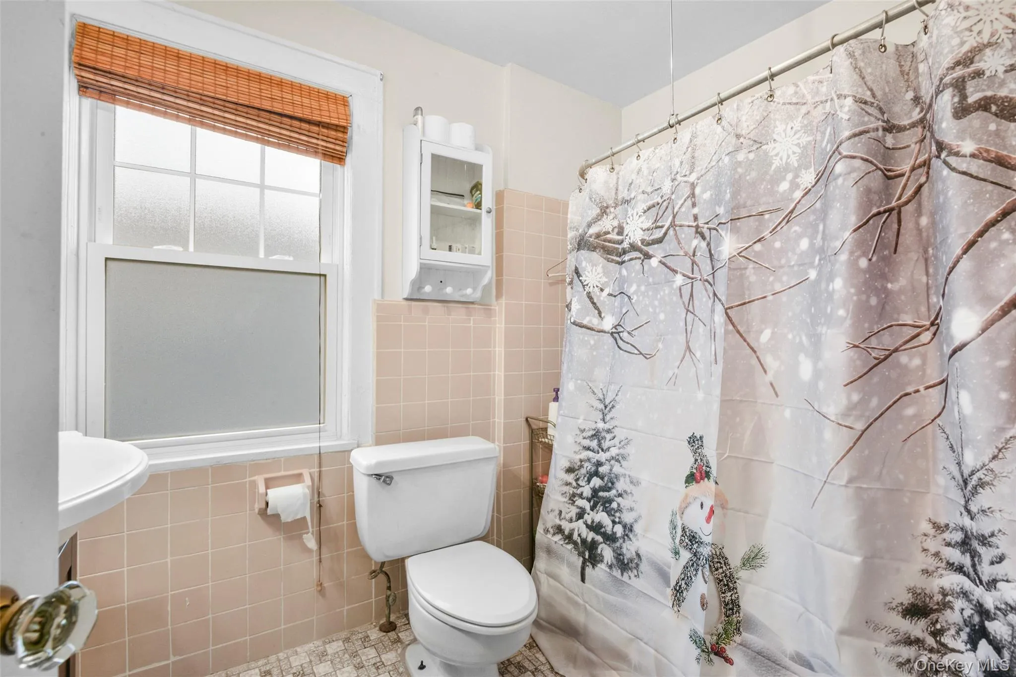 Bathroom featuring curtained shower and tile walls Bathroom featuring curtained shower and tile walls