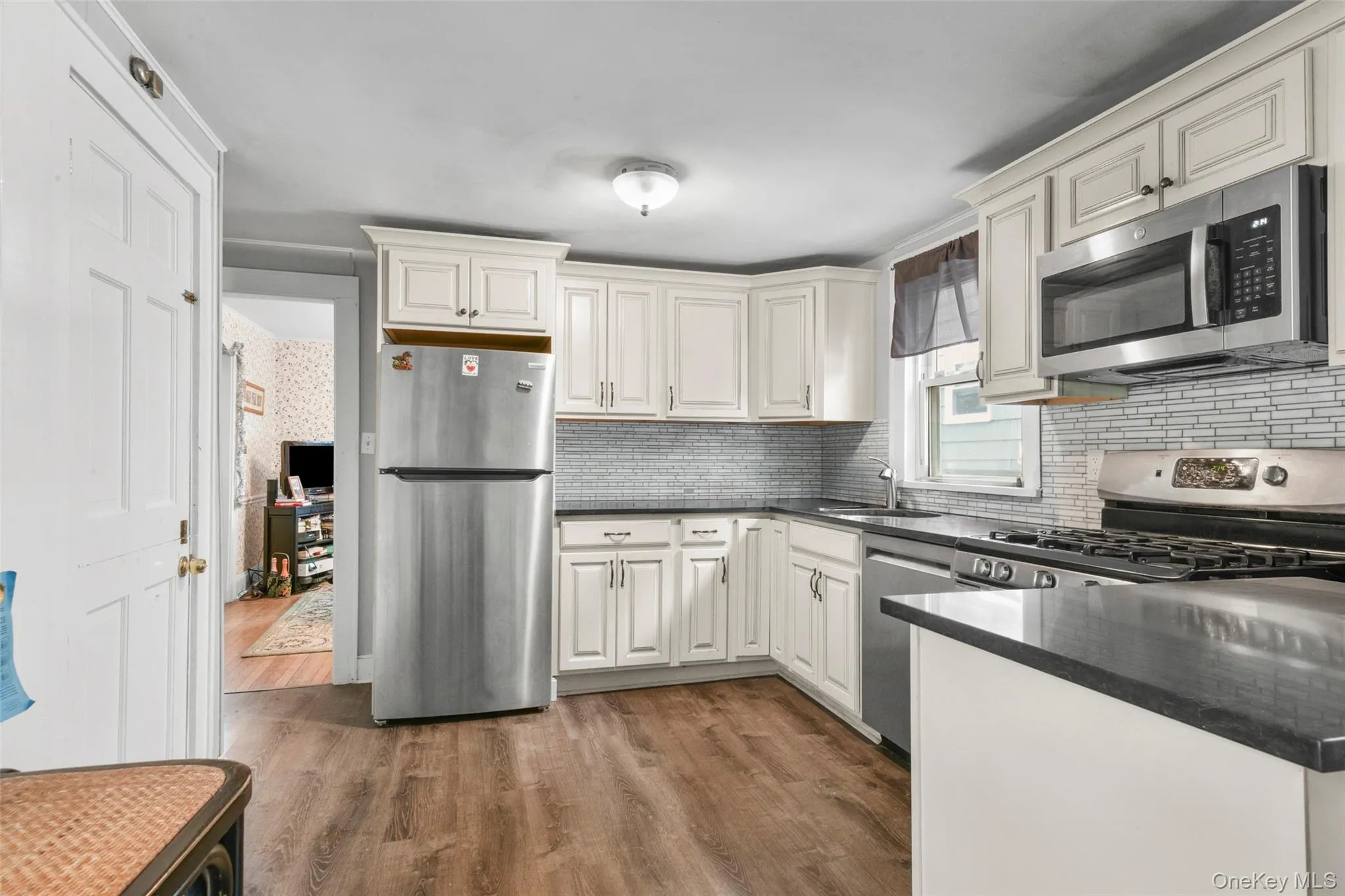 Kitchen with stainless steel appliances, dark wood finished floors, and dark stone countertops Kitchen with stainless steel appliances, dark wood finished floors, and dark stone countertops