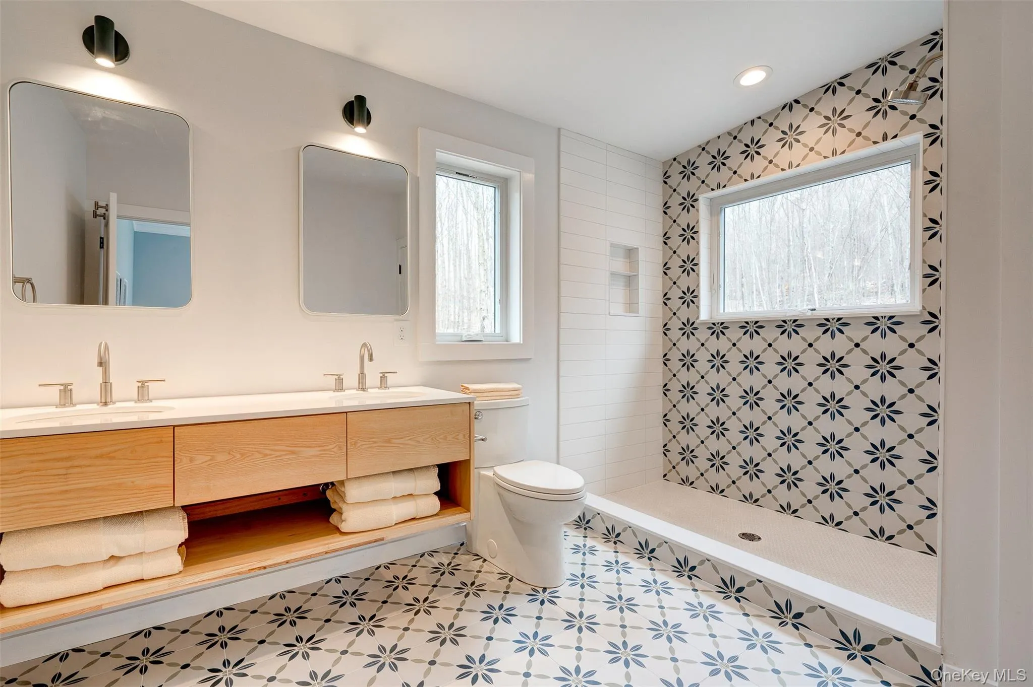 Bathroom with a stall shower, double vanity, healthy amount of natural light, and recessed lighting Bathroom with a stall shower, double vanity, healthy amount of natural light, and recessed lighting