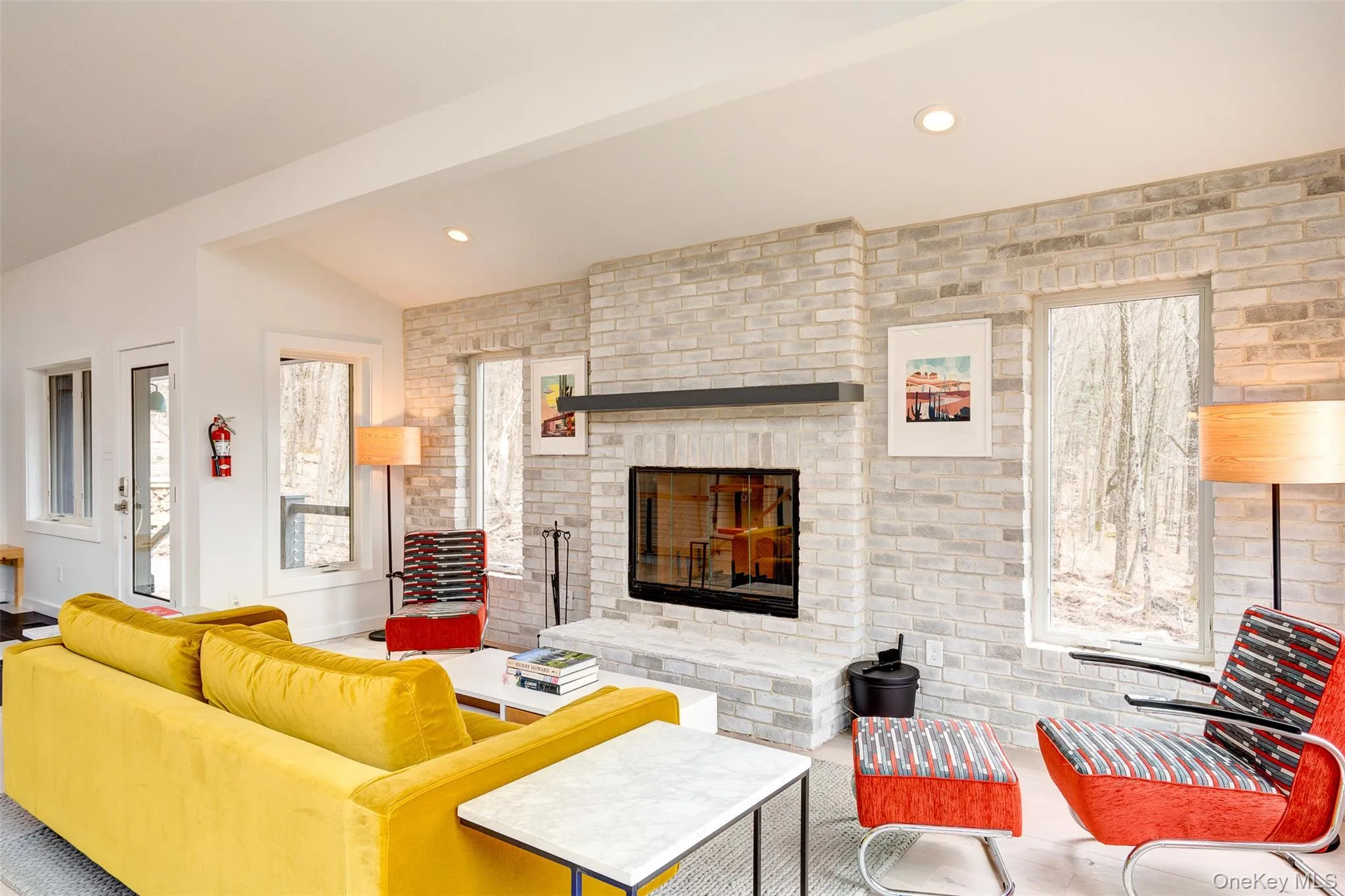 Living room with a fireplace, brick wall, and recessed lighting Living room with a fireplace, brick wall, and recessed lighting