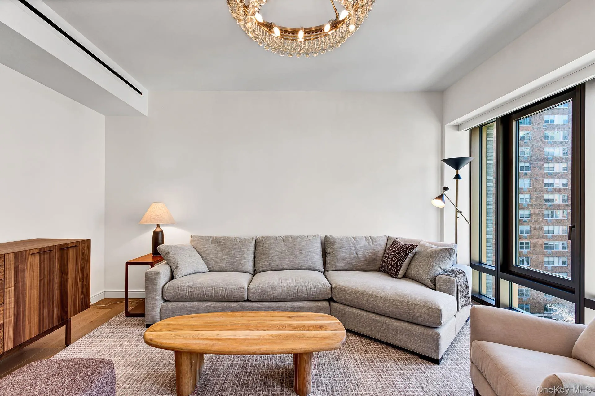 Living room with a chandelier and wood finished floors Living room with a chandelier and wood finished floors