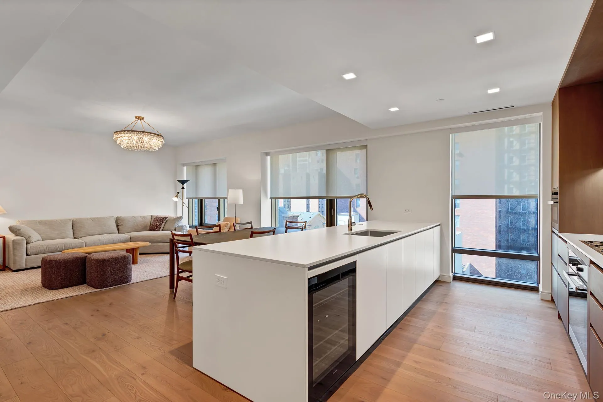 Kitchen featuring white cabinetry, a peninsula, modern cabinets, open floor plan, and light wood-style flooring Kitchen featuring white cabinetry, a peninsula, modern cabinets, open floor plan, and light wood-style flooring