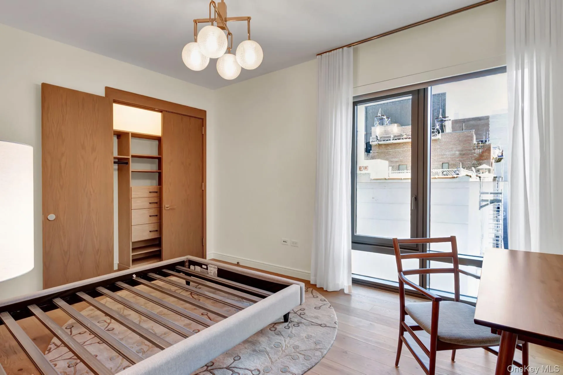 Bedroom featuring hardwood / wood-style floors, a chandelier, a closet, and baseboard heating. Bedroom featuring hardwood / wood-style floors, a chandelier, a closet, and baseboard heating.