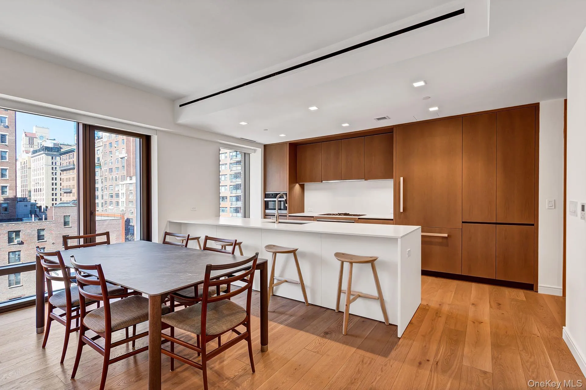 Dining room with light wood-type flooring, recessed lighting, and a city view Dining room with light wood-type flooring, recessed lighting, and a city view