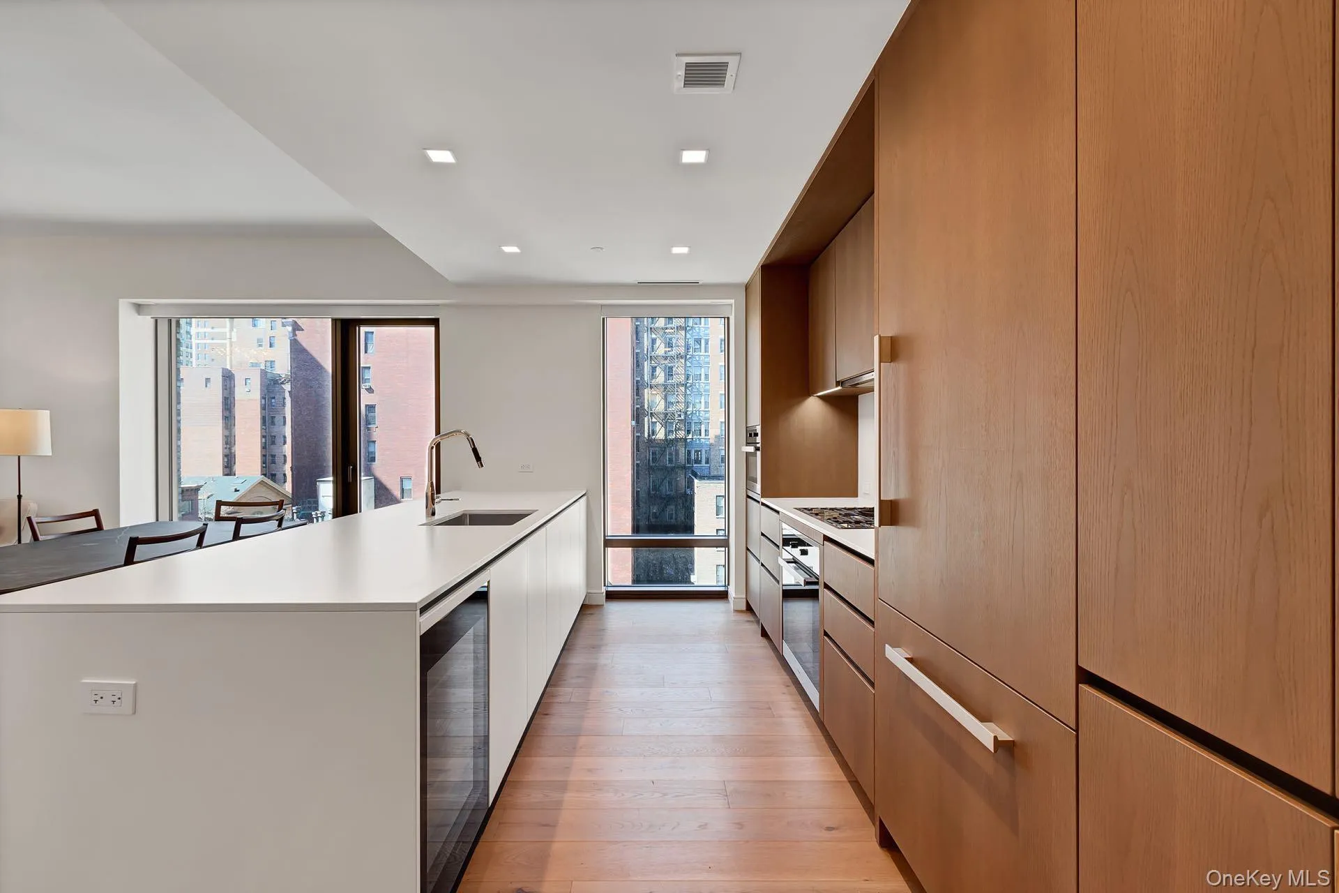 Kitchen with modern cabinets, healthy amount of natural light, recessed lighting, light wood-style flooring, and stainless steel appliances Kitchen with modern cabinets, healthy amount of natural light, recessed lighting, light wood-style flooring, and stainless steel appliances