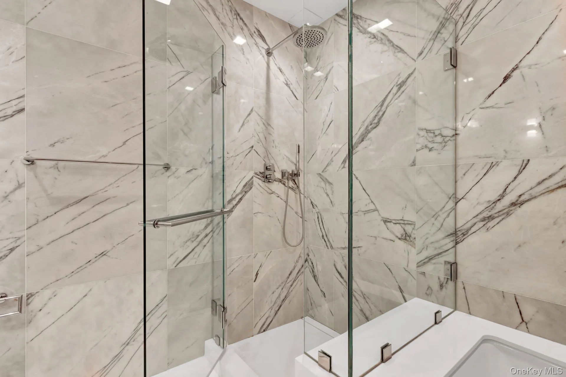 Bathroom featuring a marble finish shower Bathroom featuring a marble finish shower