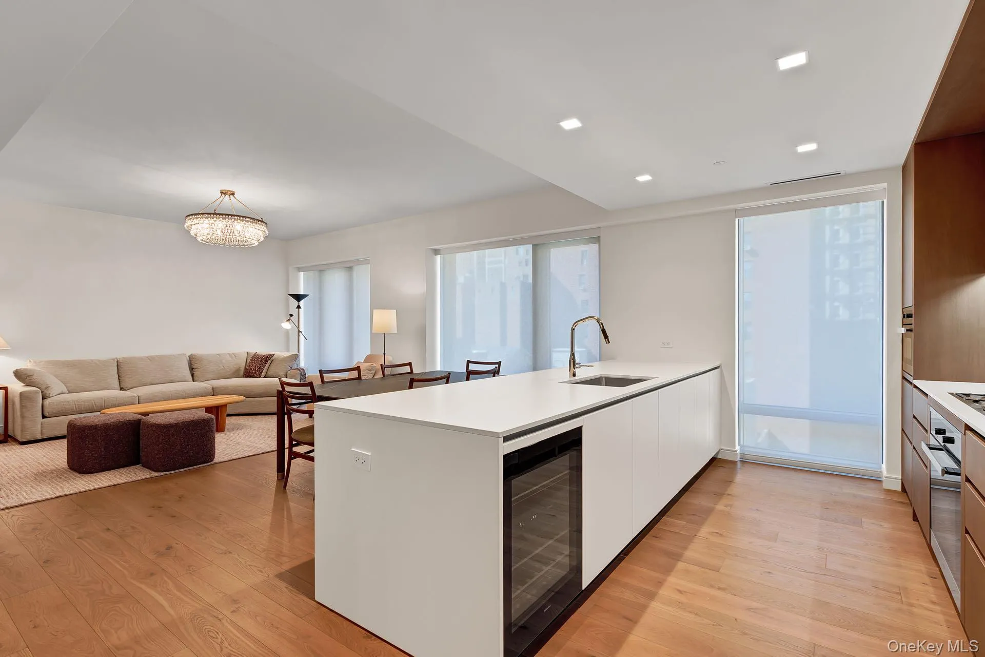 Kitchen featuring modern cabinets, a peninsula, white cabinetry, light wood-type flooring, and open floor plan Kitchen featuring modern cabinets, a peninsula, white cabinetry, light wood-type flooring, and open floor plan