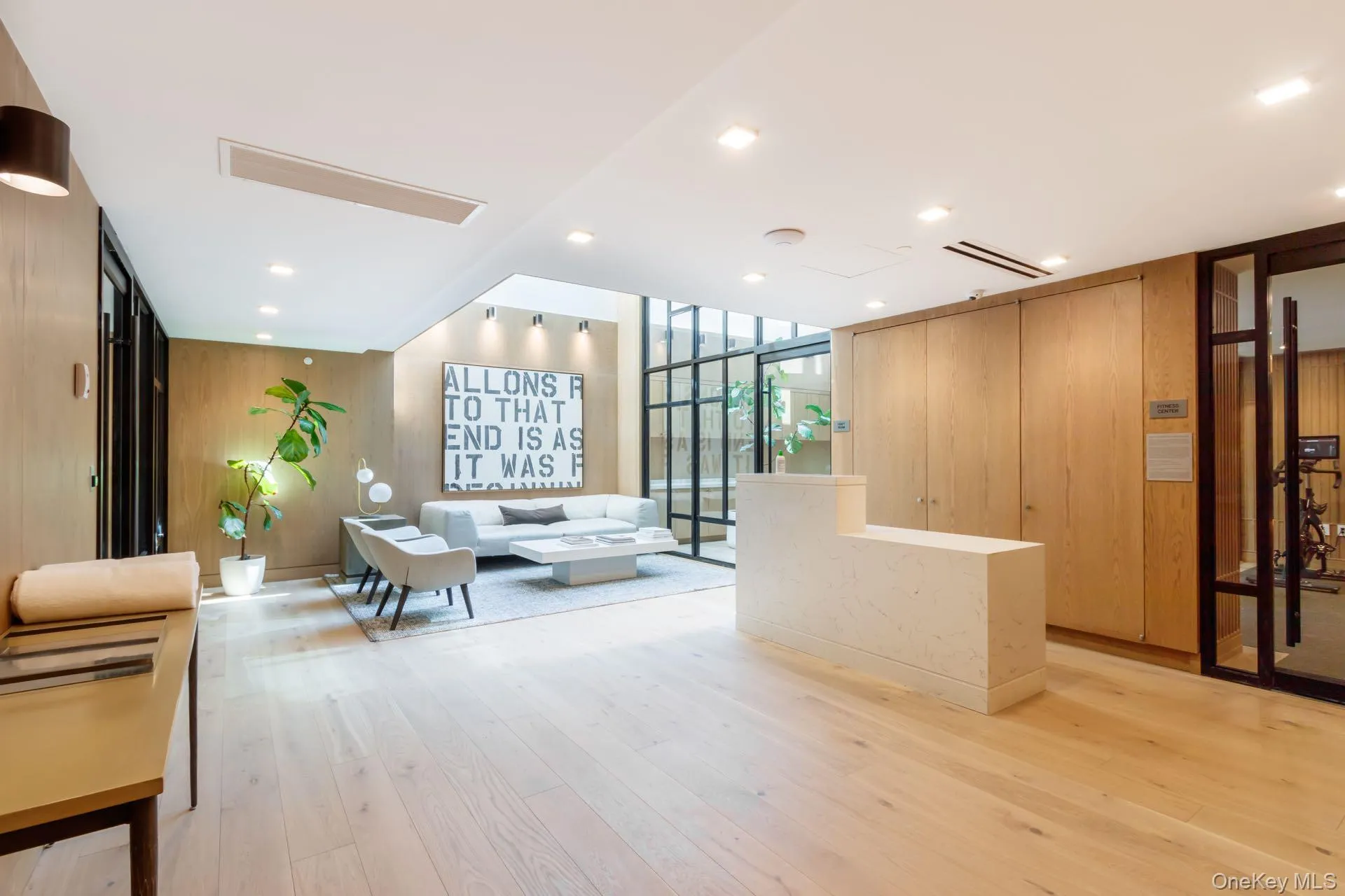 Building lobby with floor to ceiling windows, wooden walls, and recessed lighting Building lobby with floor to ceiling windows, wooden walls, and recessed lighting