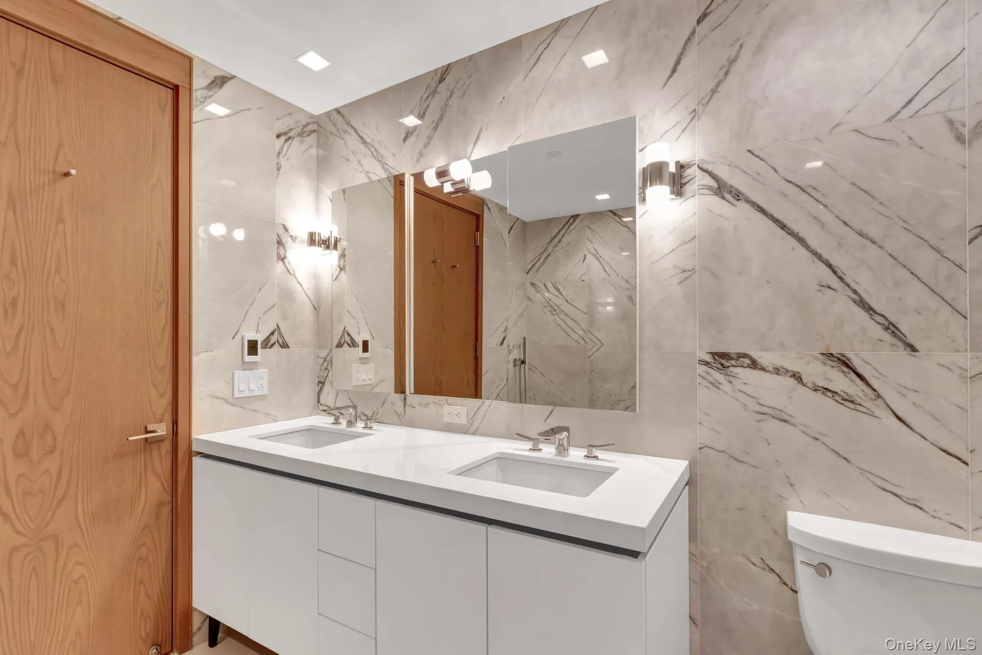 Full bath with double vanity, tile walls, and stone wall Full bath with double vanity, tile walls, and stone wall