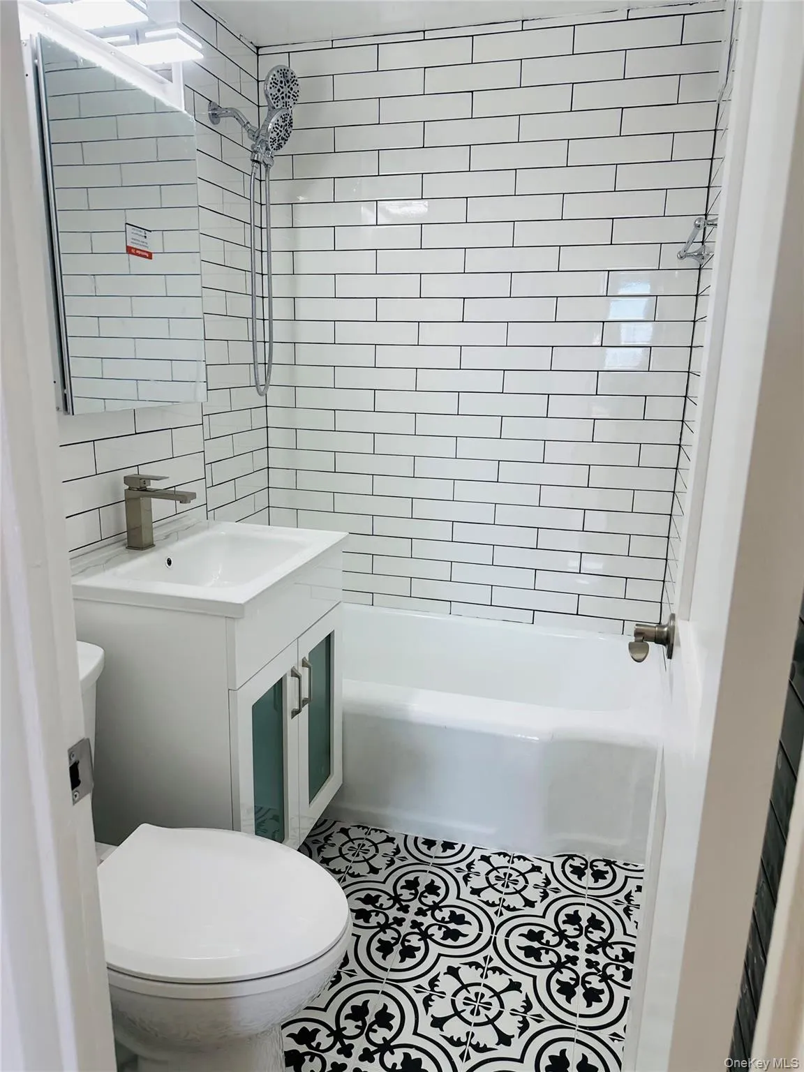 Full bath with vanity, shower / washtub combination, tile patterned floors, and tile walls Full bath with vanity, shower / washtub combination, tile patterned floors, and tile walls
