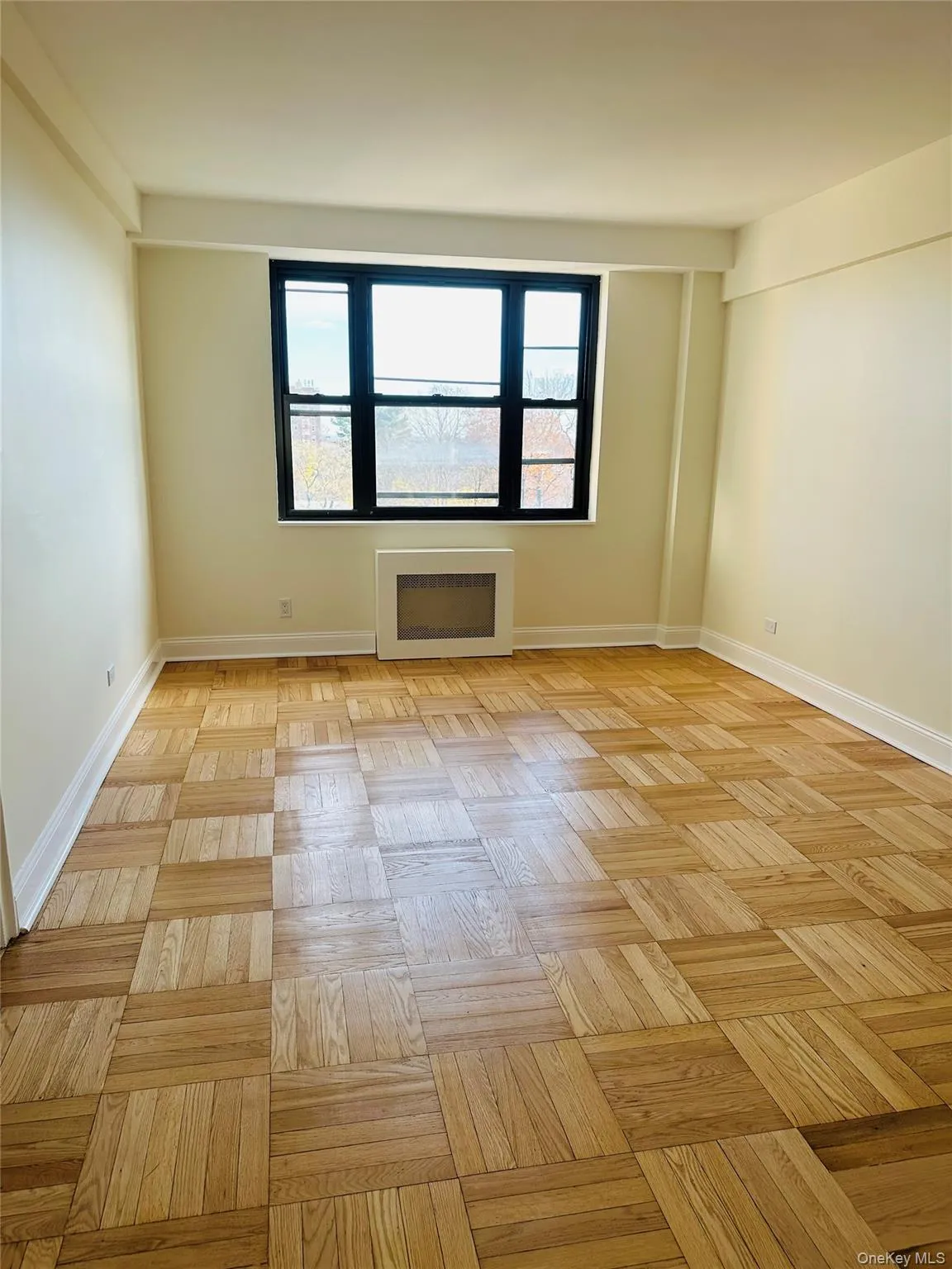 Unfurnished room with plenty of natural light and radiator heating unit Unfurnished room with plenty of natural light and radiator heating unit