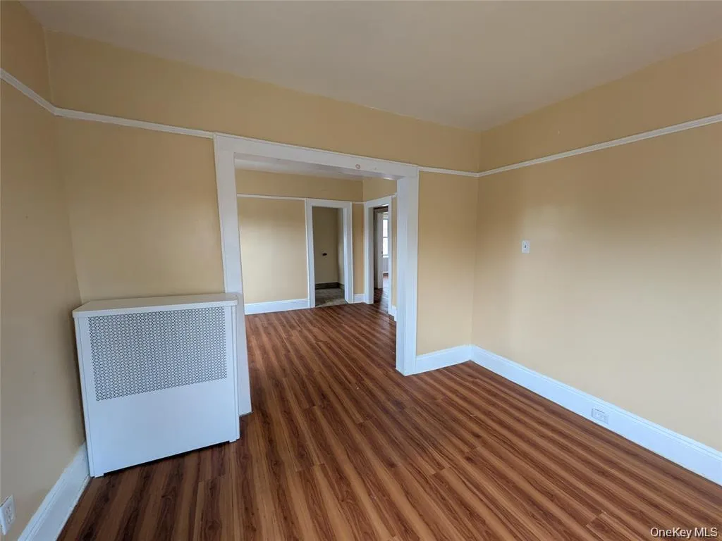 Empty room with dark wood finished floors and radiator Empty room with dark wood finished floors and radiator