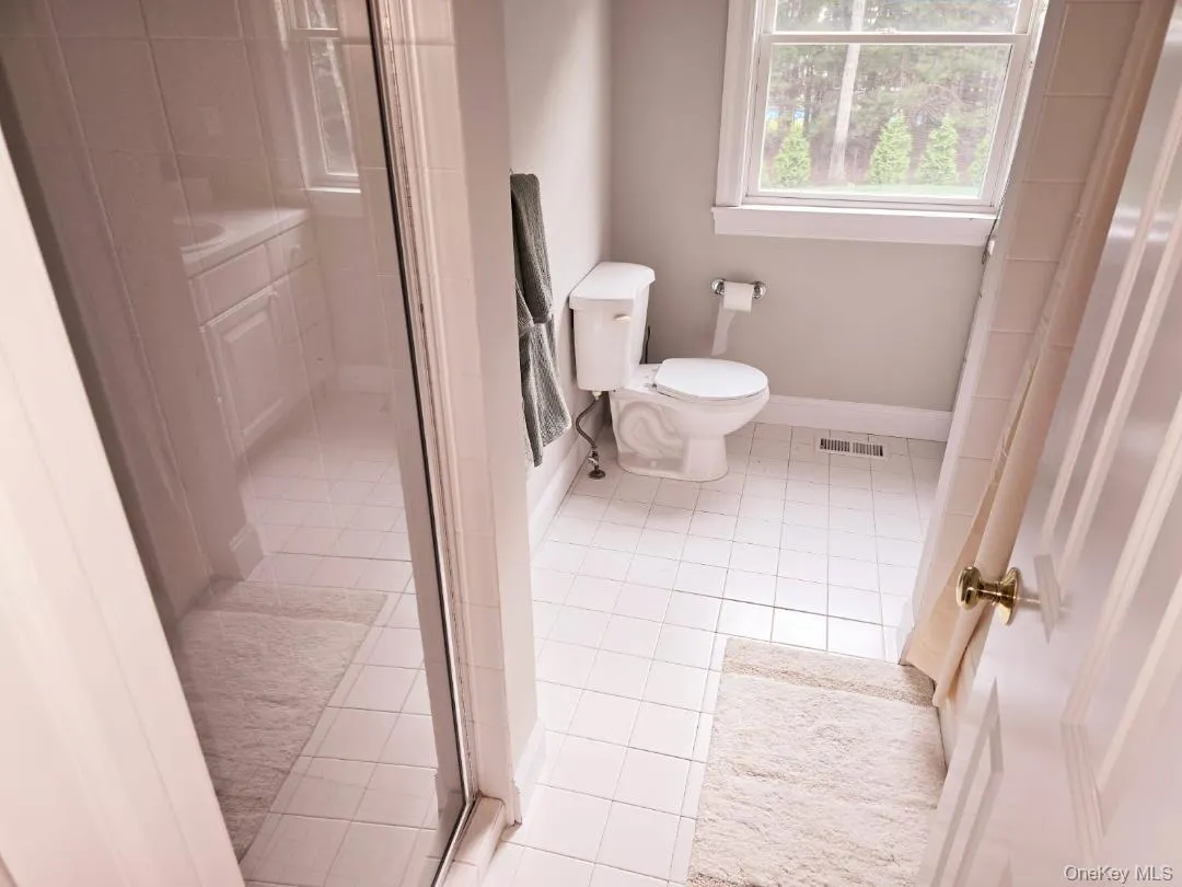 Full bathroom featuring light tile patterned flooring and a stall shower Full bathroom featuring light tile patterned flooring and a stall shower
