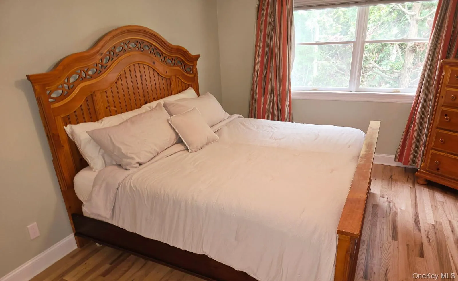 Bedroom featuring wood finished floors and baseboards Bedroom featuring wood finished floors and baseboards