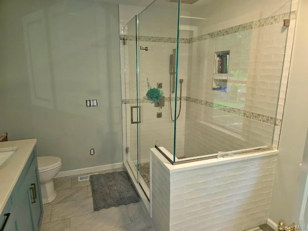 Bathroom featuring vanity, a stall shower, and light tile patterned floors Bathroom featuring vanity, a stall shower, and light tile patterned floors