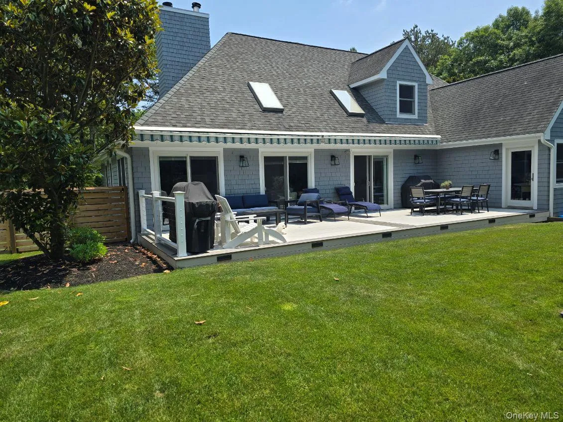 Rear view of house featuring a shingled roof, a chimney, an outdoor living space, and a wooden deck Rear view of house featuring a shingled roof, a chimney, an outdoor living space, and a wooden deck