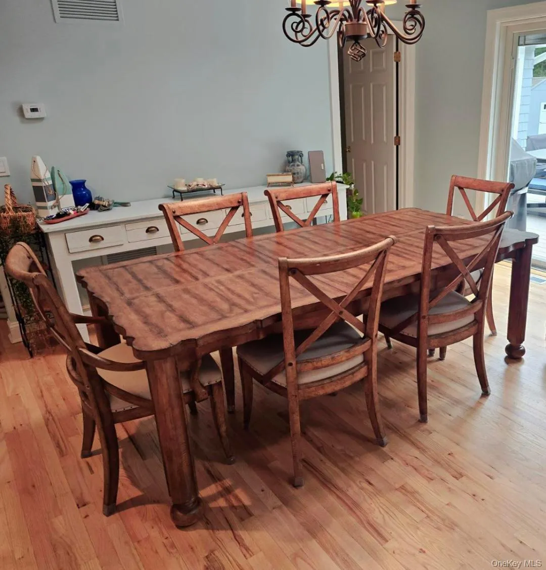 Dining space with a chandelier and light wood-style flooring Dining space with a chandelier and light wood-style flooring