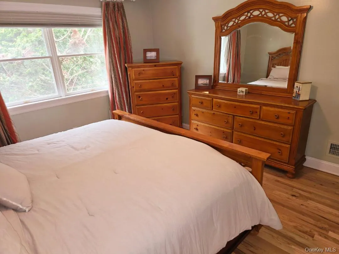 Bedroom with light wood finished floors and baseboards Bedroom with light wood finished floors and baseboards