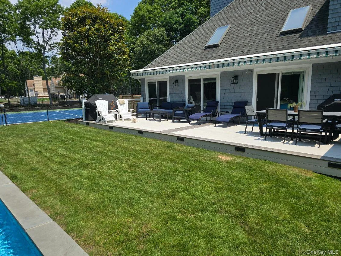Back of property featuring roof with shingles and a wooden deck Back of property featuring roof with shingles and a wooden deck