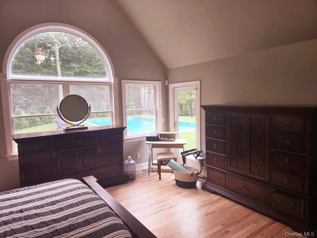 Bedroom with vaulted ceiling and light wood-style flooring Bedroom with vaulted ceiling and light wood-style flooring