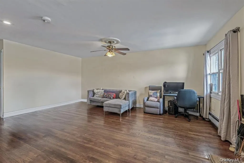 Office space with dark wood-style flooring and ceiling fan Office space with dark wood-style flooring and ceiling fan