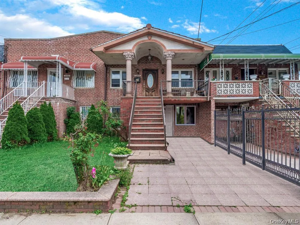 View of front of property with stairway, brick siding, and covered porch View of front of property with stairway, brick siding, and covered porch