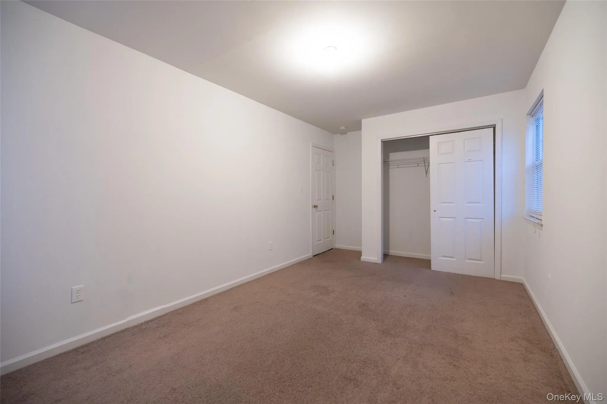 Unfurnished bedroom featuring carpet flooring and a closet Unfurnished bedroom featuring carpet flooring and a closet