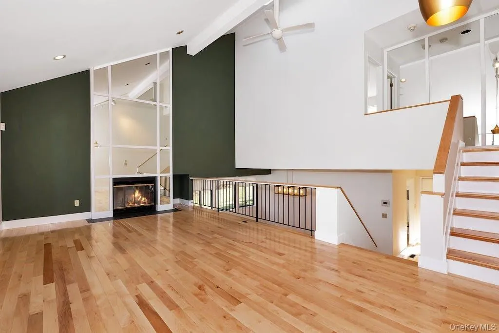 Living room with wood burning fireplace (overlooks dining room), stairs up to primary suite. Living room with wood burning fireplace (overlooks dining room), stairs up to primary suite.