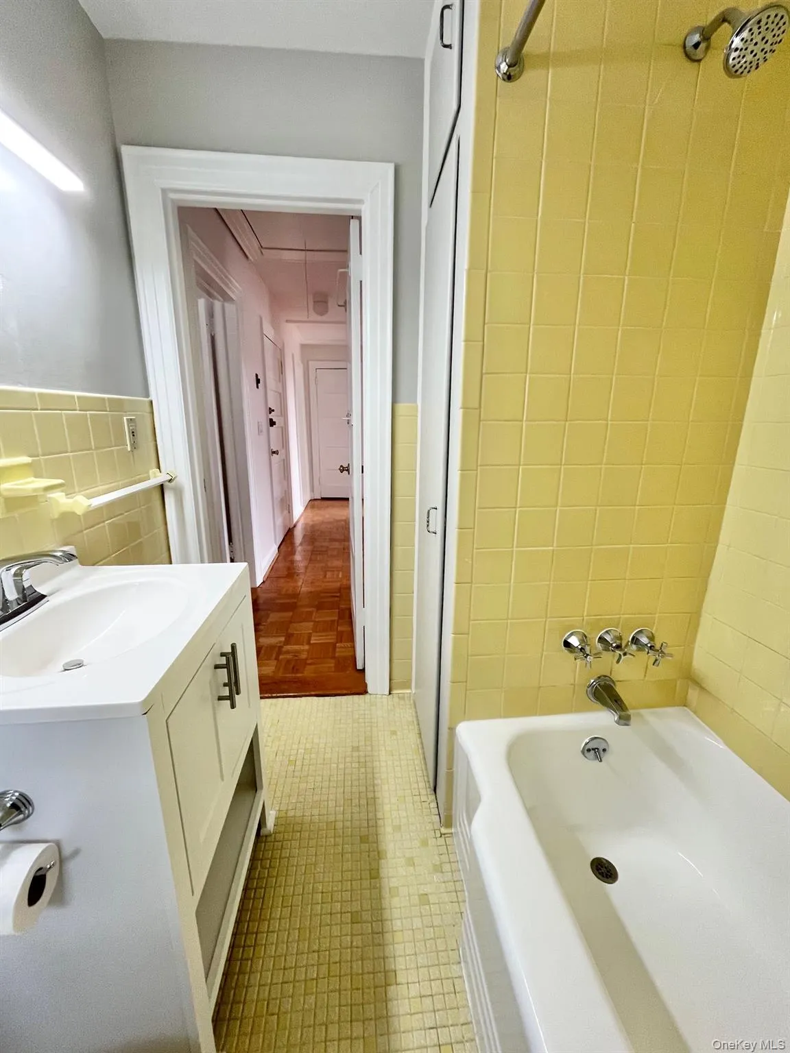 Bathroom featuring shower / bath combination, vanity, and tile walls Bathroom featuring shower / bath combination, vanity, and tile walls