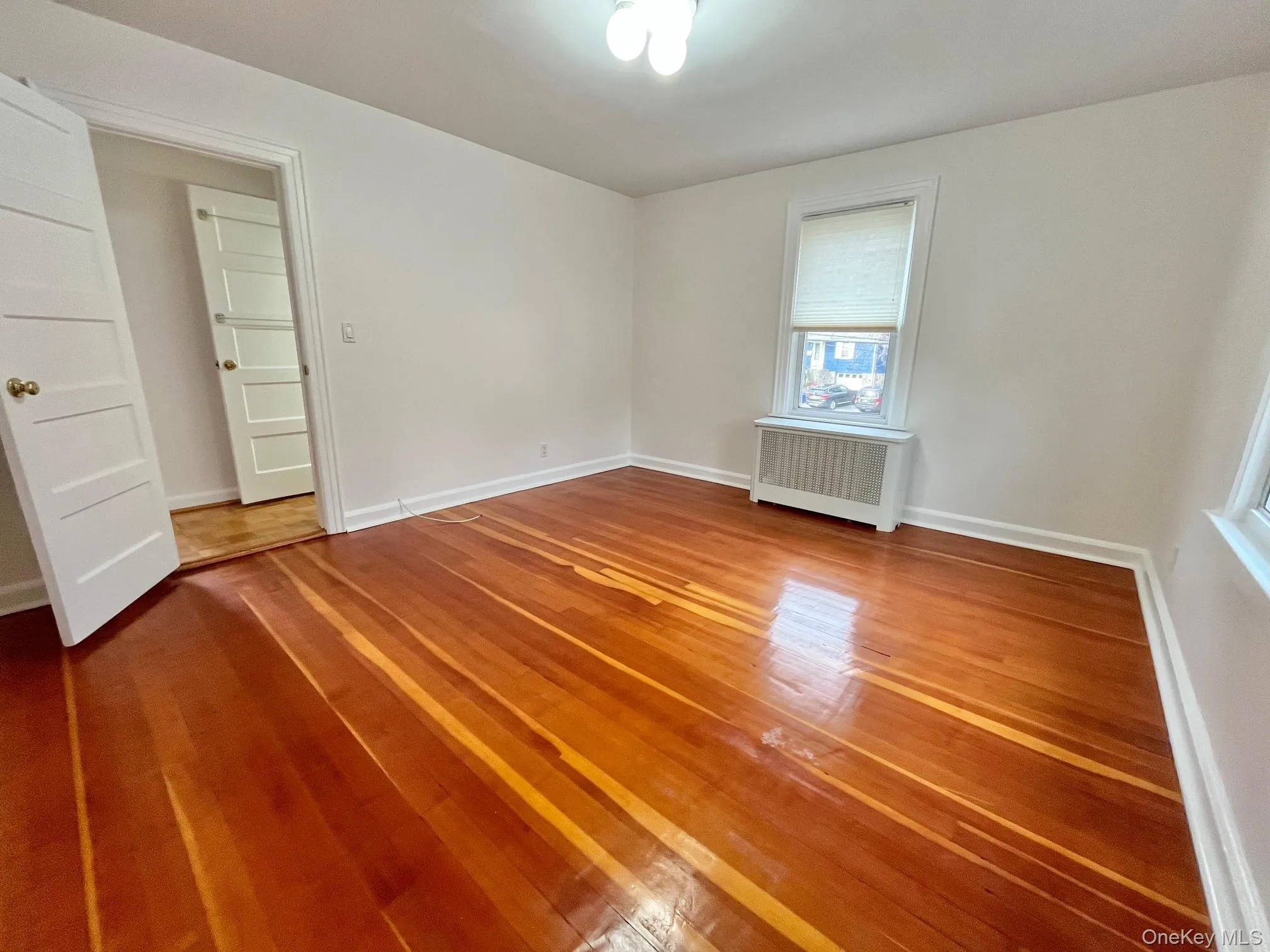Unfurnished room featuring light wood-style floors and radiator Unfurnished room featuring light wood-style floors and radiator